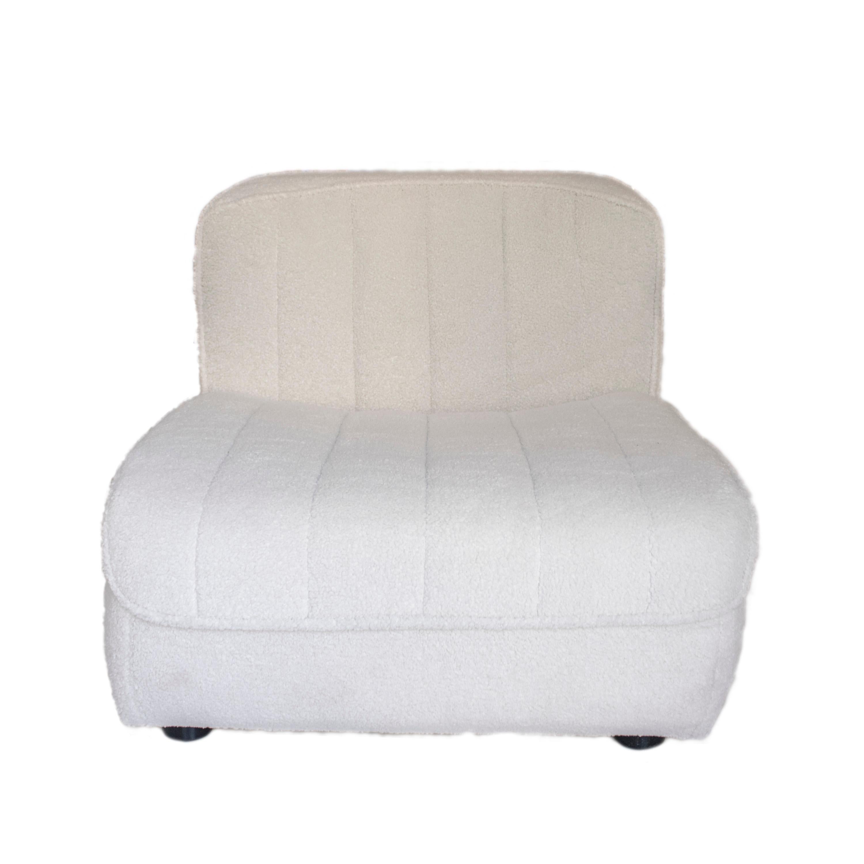 Modular sofa composed of six sections upholstered in beige bouclé with hand-stitched details. The combination of the units forms an L-shaped sofa with the flexibility to move and create different arrangements. 