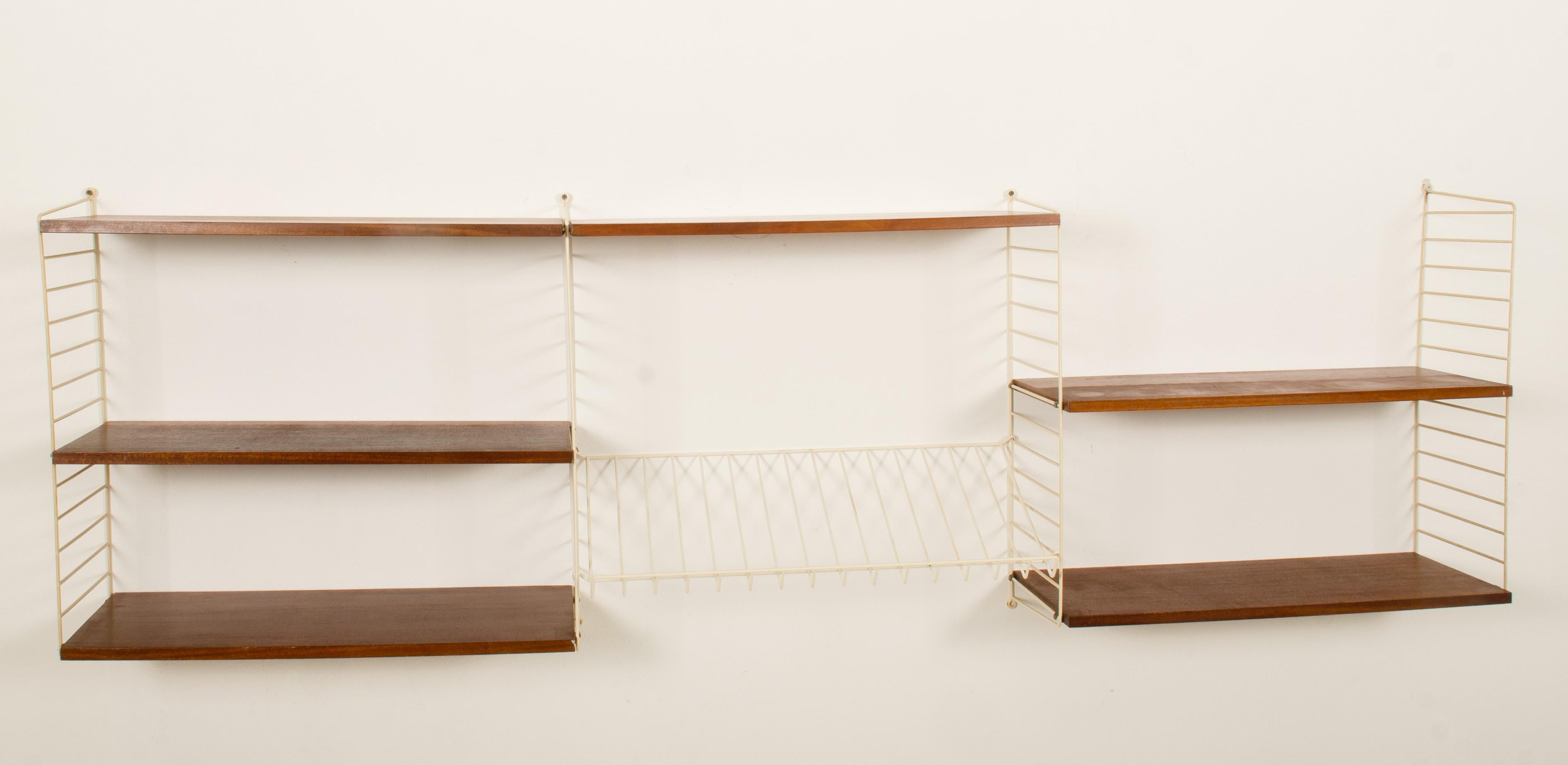 String wall shelf wall unit designed by Nils and Kajsa Strinning in 1949. This one was made in the 1960s in Sweden.
A good vintage condition, traces of use due to the age, yellowed hanger used marks on the shelf.
