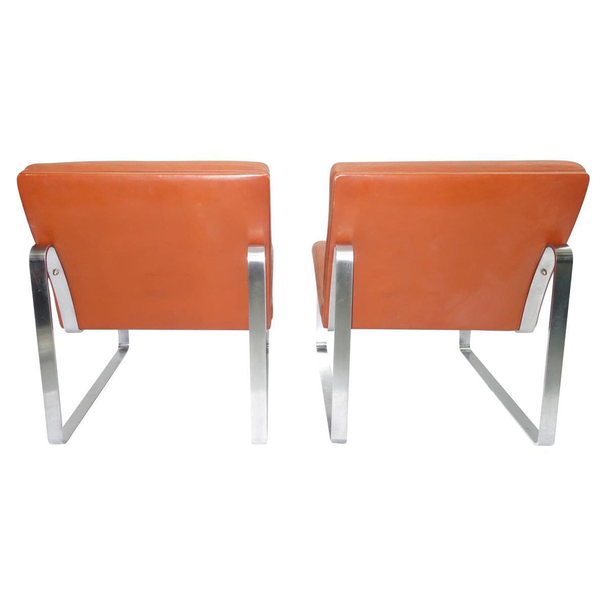 Stunning pair of lounge chairs in reddish brown leather on steel legs. Designed by Ole Gjerløv-Knudsen and Torben Lind as part of the Moduline series in 1961 and manufactured by France & Son. These chairs are a rare edition of Moduline which is