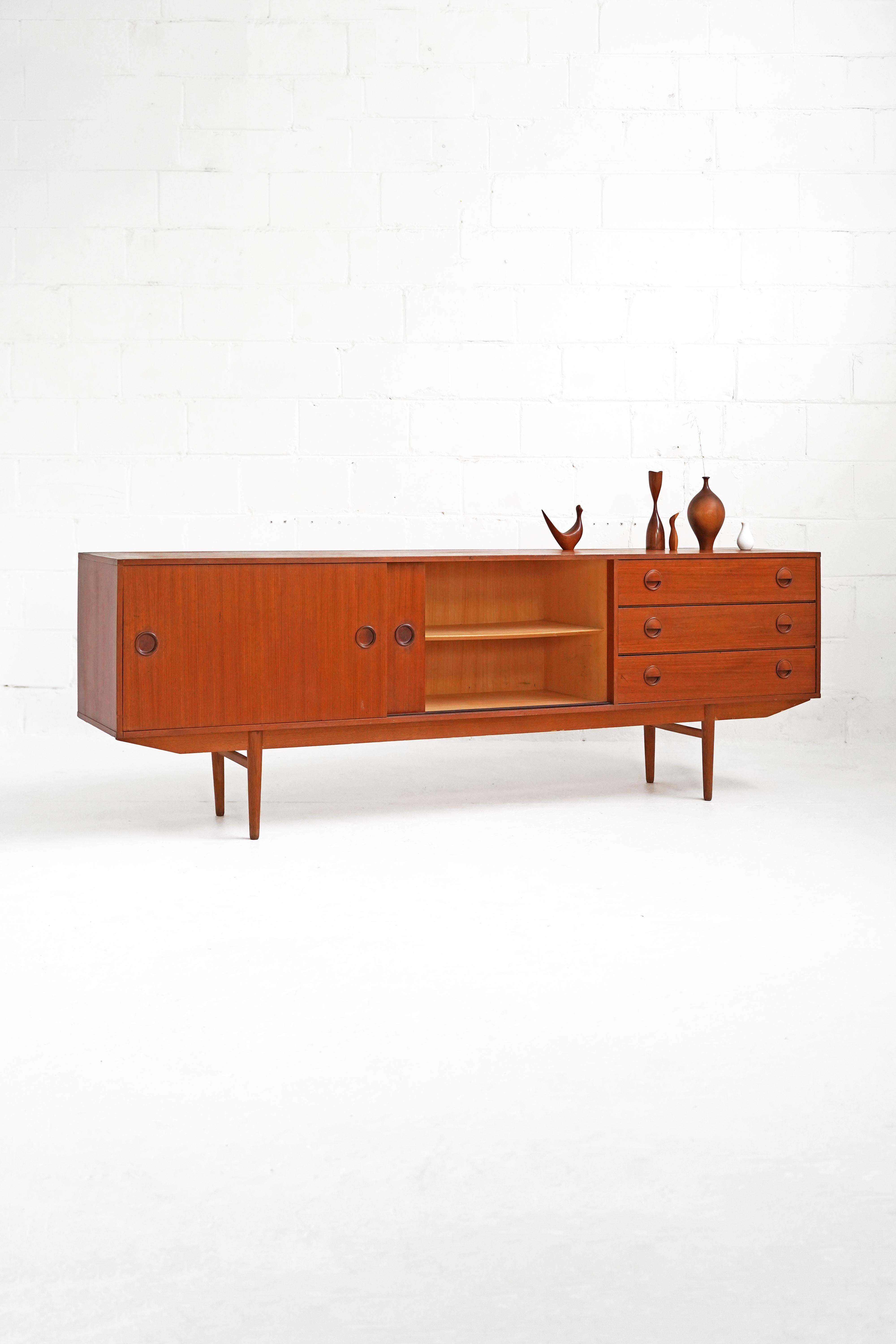 Stunning sideboard for Fristho Franeker, with 2 sliding doors, 3 drawers, and 1 hidden pull out shelf behind left door. In good vintage original condition with general wear throughout the piece, showing minor fading, light scratching and faint