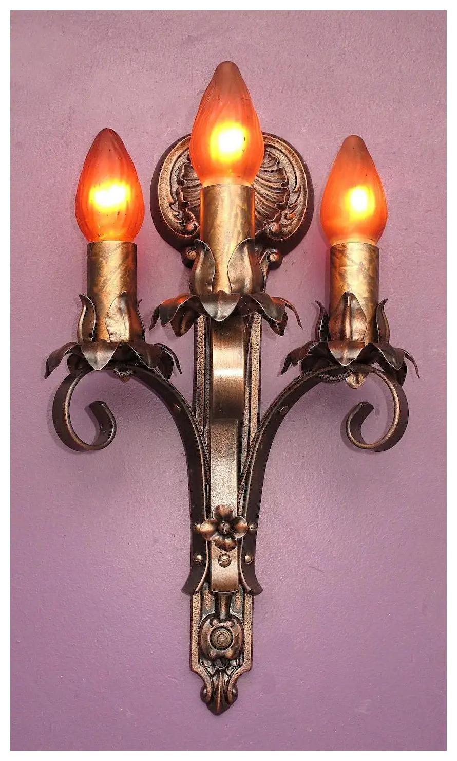 Priced per pair with 7 pair available.
Wonderful vintage three-arm wall sconces with six available. Classic in design and style with an excellent shell rosette at top giving them a slight nautical feel. All of these antique sconces are signed 