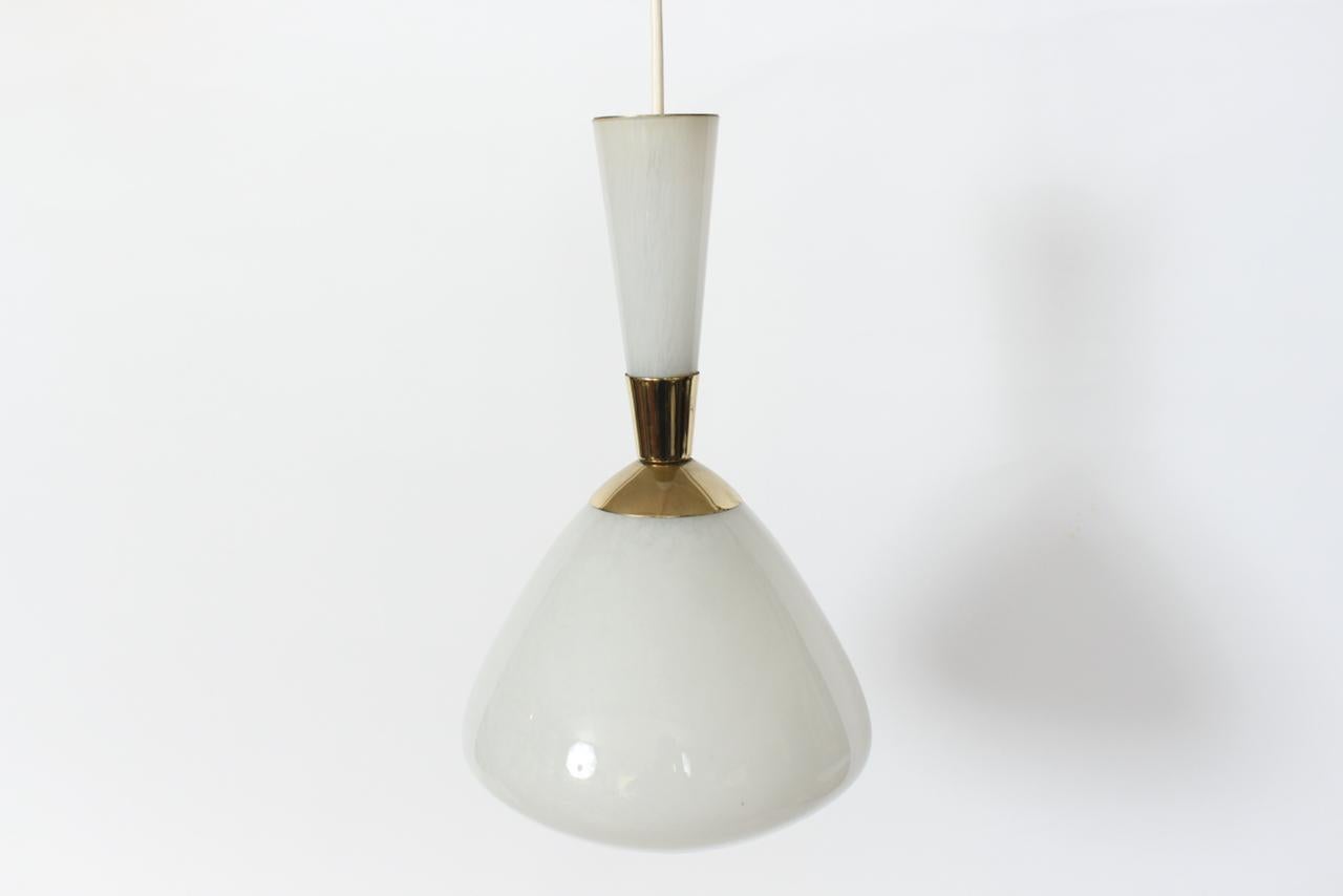Moe Lighting Co. hand blown White Glass Hanging Lamp with Brass details. Featuring a two piece luminescent white on white translucent glass pendant, with 2.5W x 5.25H top glass handle section capped with Brass accent, flared two part Brass waist, 9W