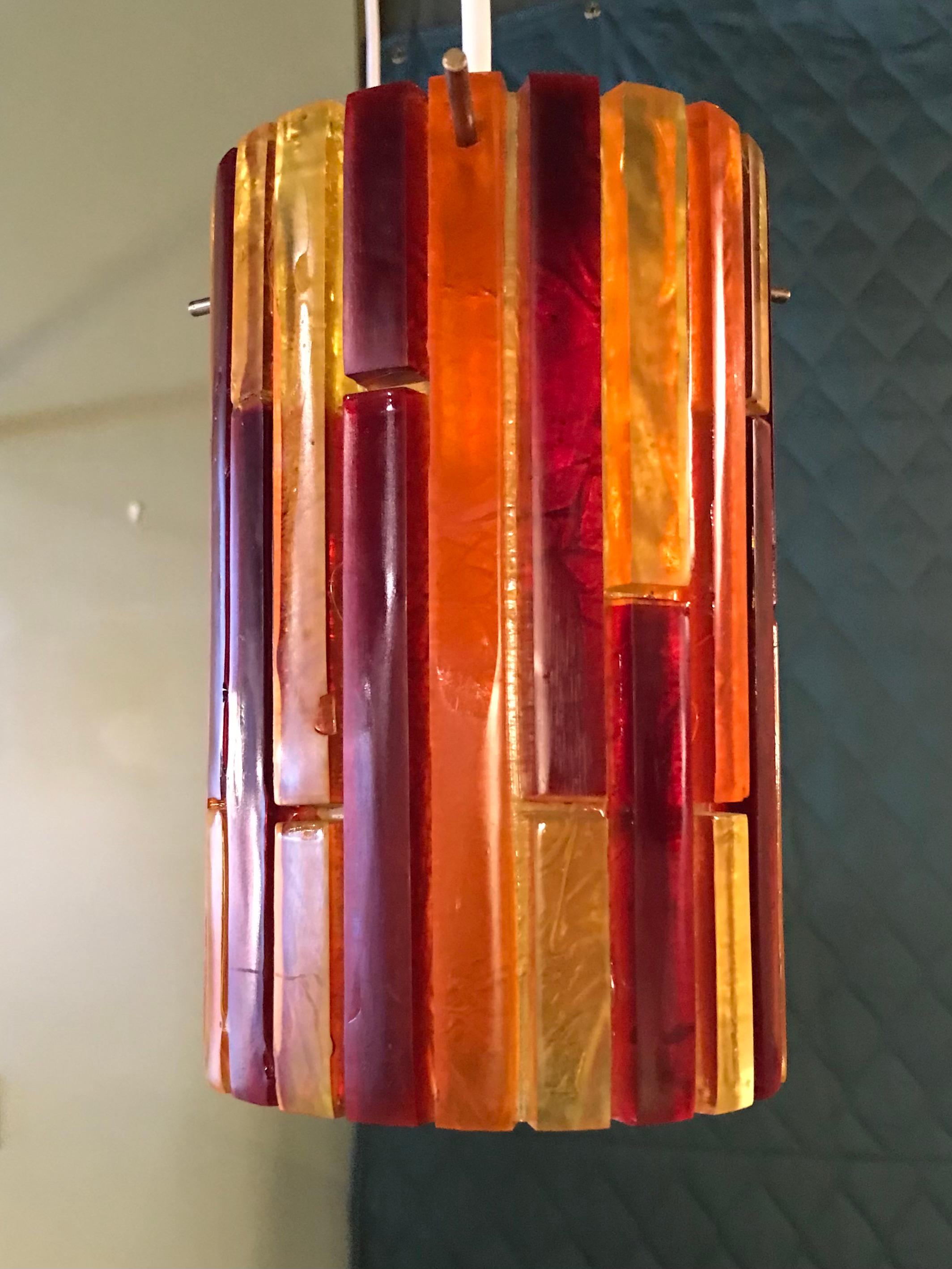 Colorful pair of acrylic pendants from the Fiesta series 1965 by Moe Lighting. Consisting of perpendicular slabs of red, yellow and orange rendered in a heavy acrylic. Newly rewired. Both in Very Good condition.

Measurements: 5 inches diameter x