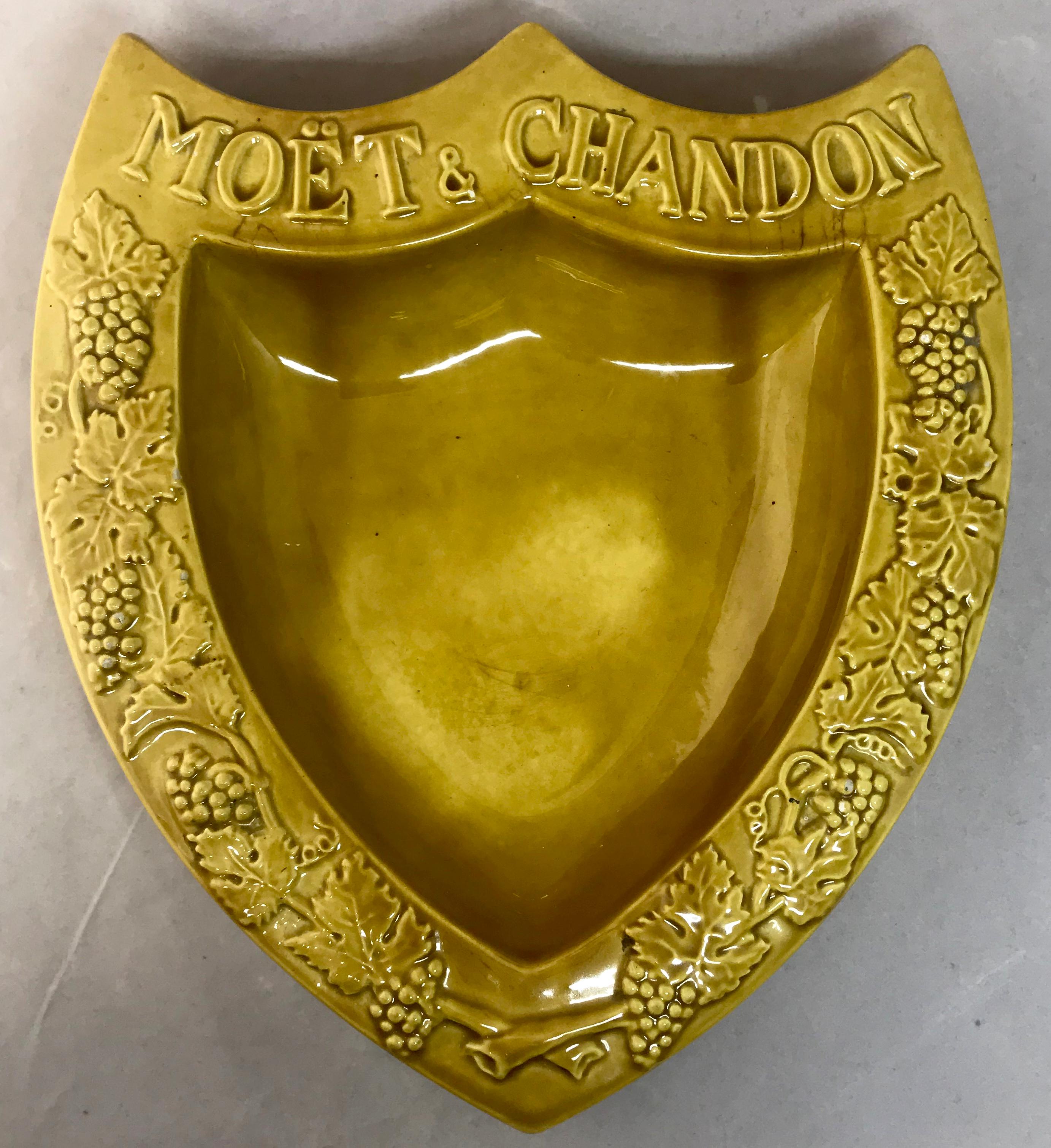 Moët & Chandon vide poche. Large glazed terracotta shield-shaped chartreuse color svuota tasca, France, mid-20th century.
Dimensions: 8.5