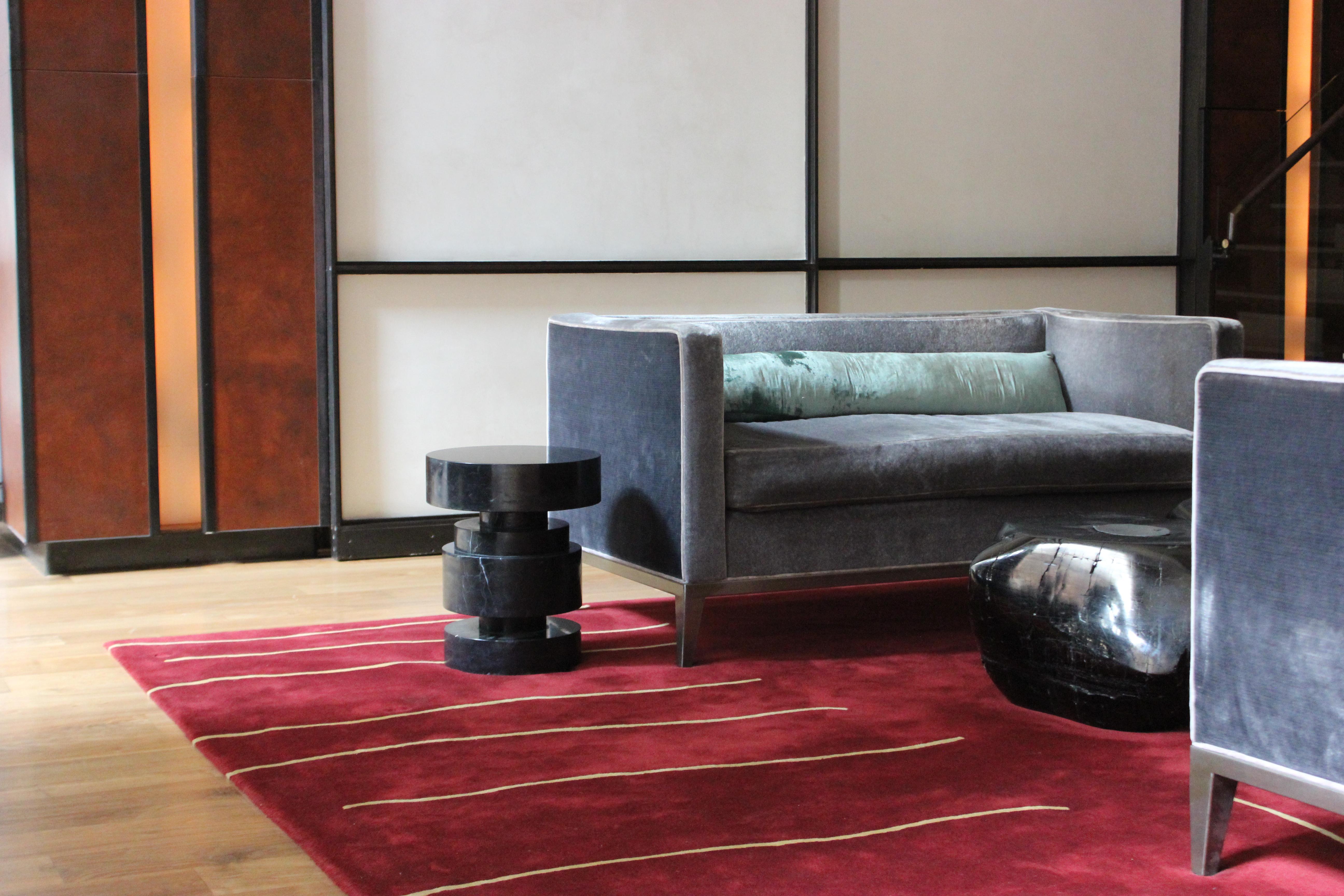 Sculptural side table carved from a solid block of nero marquina marble. Multiple pieces can be grouped together as a cocktail table. Available in custom sizes and shapes. We also partner with clients to develop customized sculptural forms that can