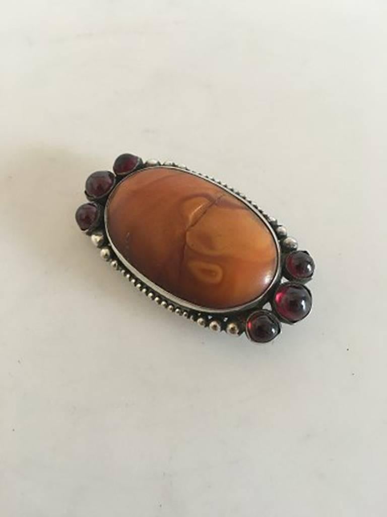 Mogens Ballin Silver Brooch with Amber and Red Stones. In good condition, but the large amber stone has a crack down the middle. Measures 5.5 x 3 cm /    2 11/64 in. x 1 3/16 in. Weighs 21.6 g / 0.76 oz.