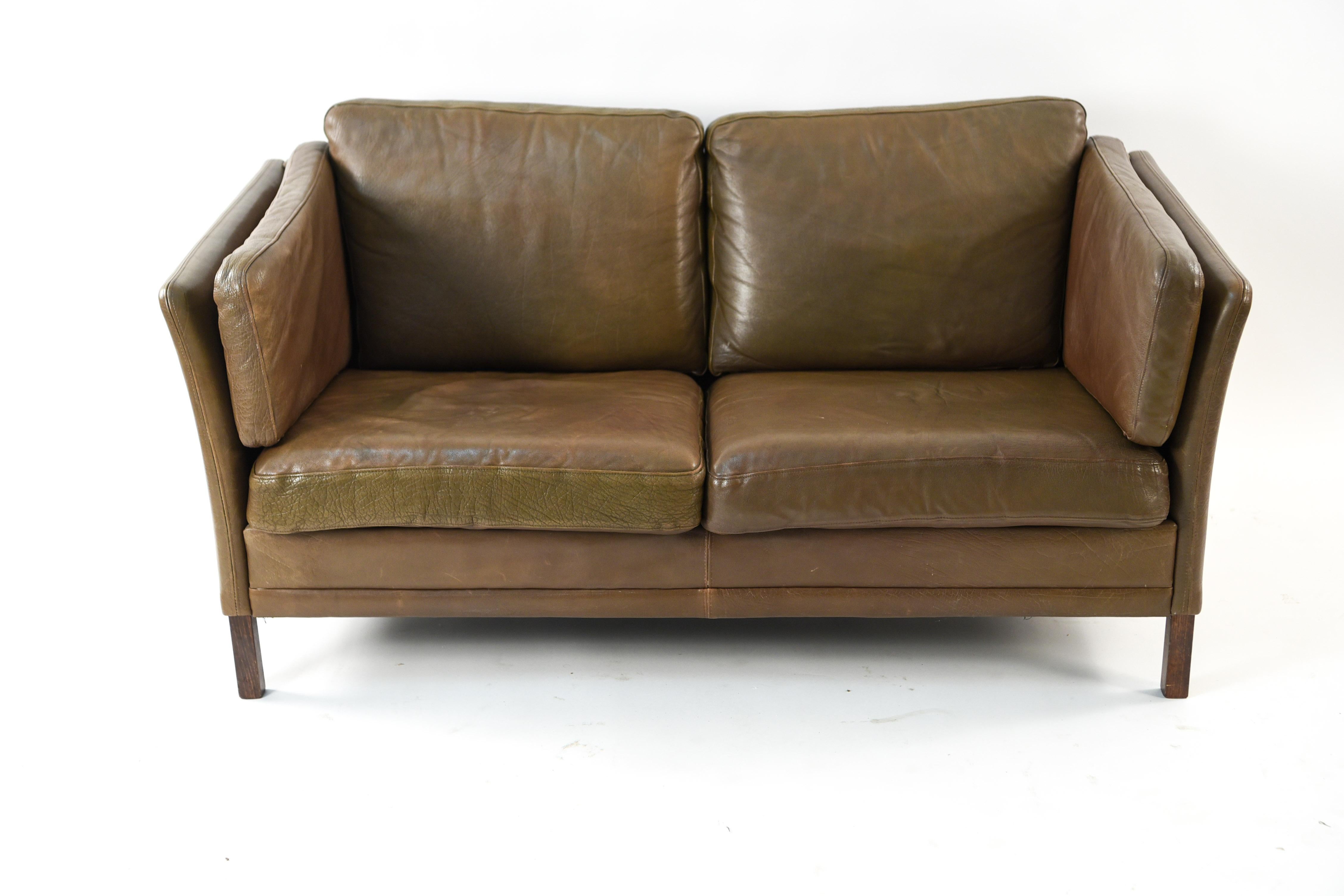 This loveseat is in the manner of designer Borge Mogensen and was manufactured by Mogens Hansen, circa 1970s. Upholstered in analine buffalo hide which has acquired an attractive, desirable patination from time and use.