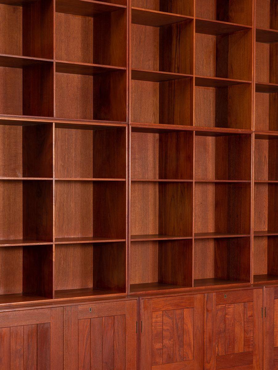 Modular bookcase unit executed in teak, designed by Mogens Koch for Rud Rasmussen. This impressive set is comprised of nine individual units, including 6 bookshelves and 3 base cabinets for hidden storage. A flexible design, the bookshelves can be