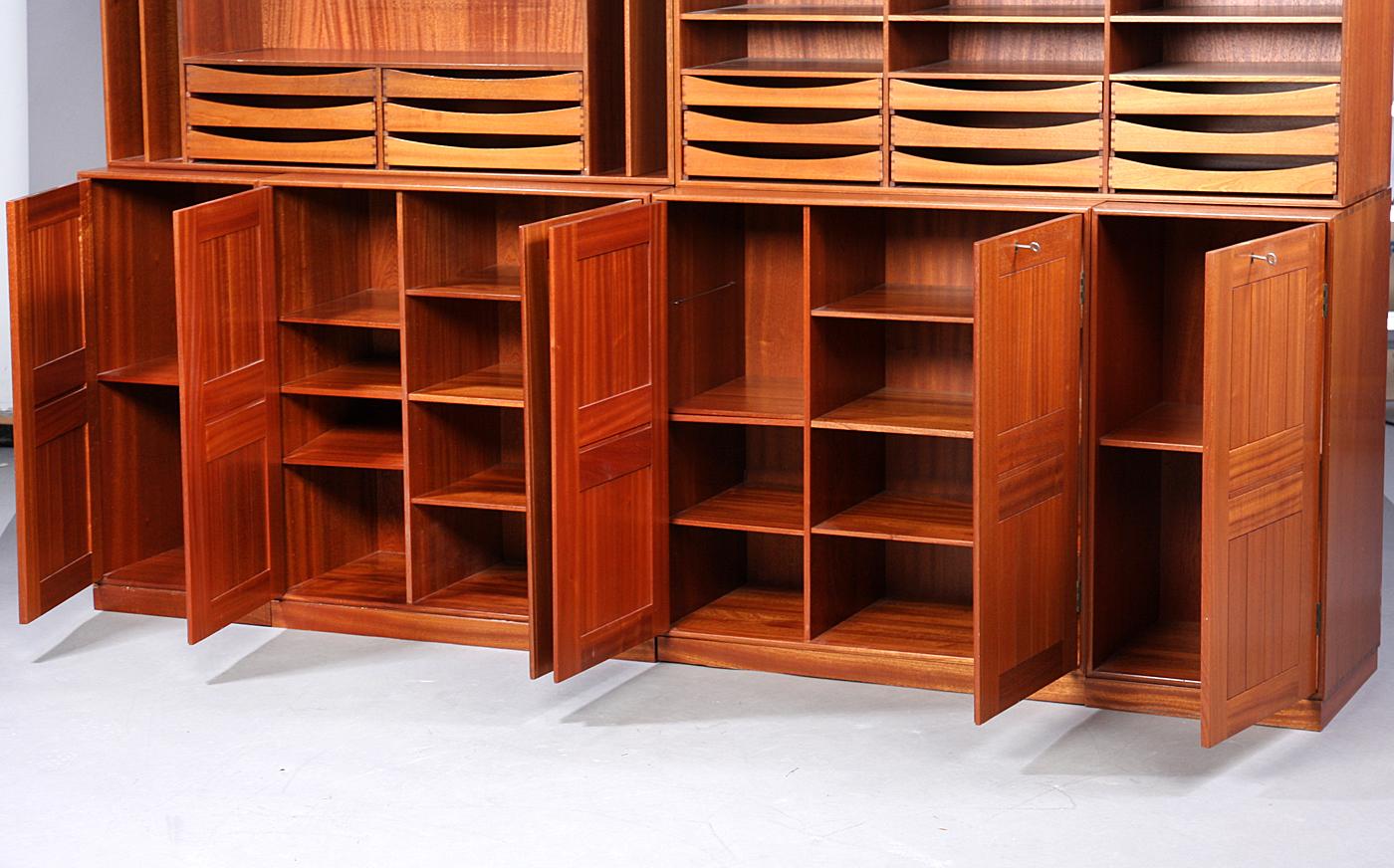 Mogens Koch, 1898-1992. Shelf wall in the form of six shelving modules and four mahogany bases, best. Of two modules, each with two doors, H. 76, B. 76, D. 36 cm. 2 modules with door H. 76, B. 38, D. 36 cm. two modules with pull-out trays, shelves