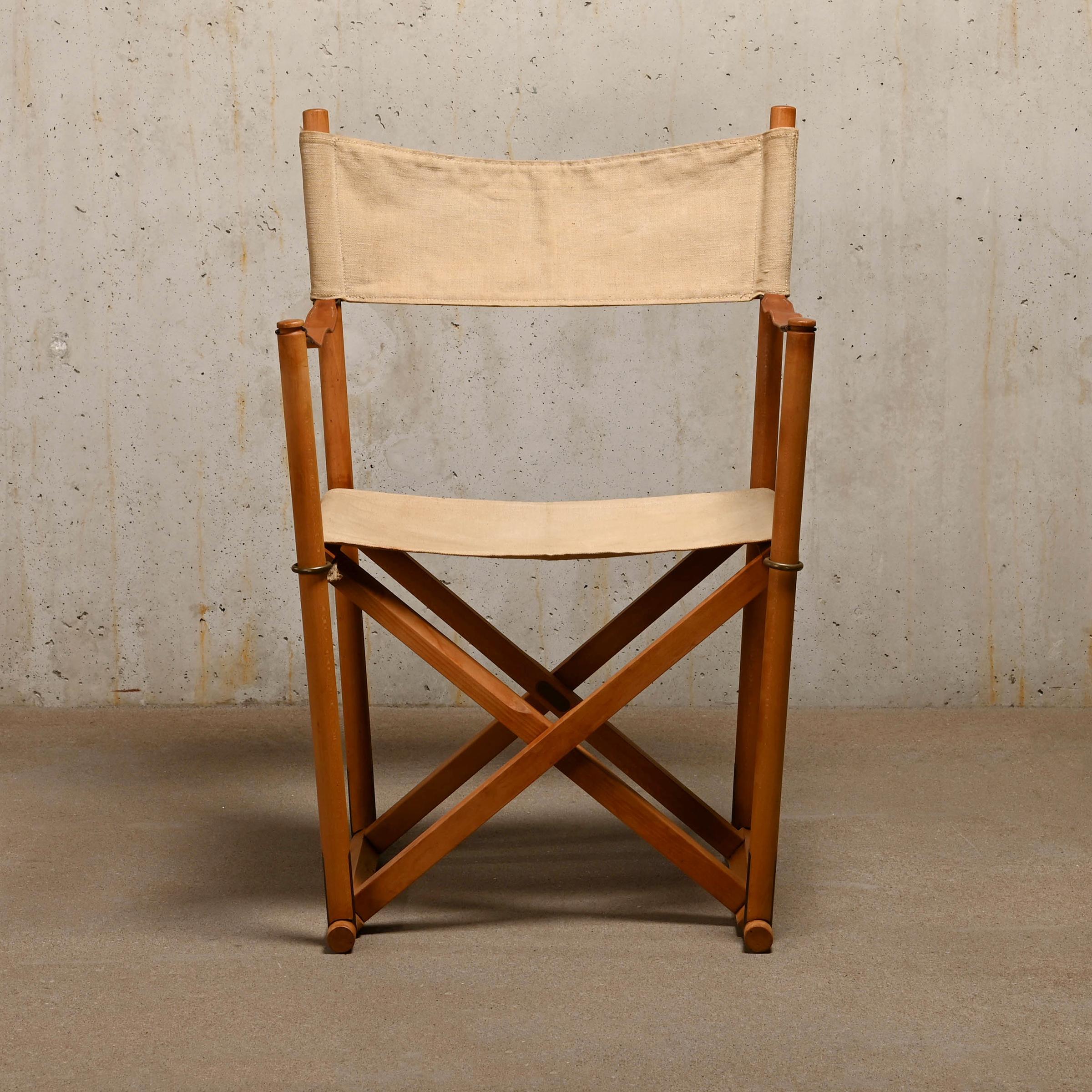 Beautiful made Folding Chair (model MK16) designed by Mogens Koch in the early thirties. This example is manufactured by Interna Denmark and features a beech wood frame with brass fittings and canvas upholstery with full-grain leather straps.