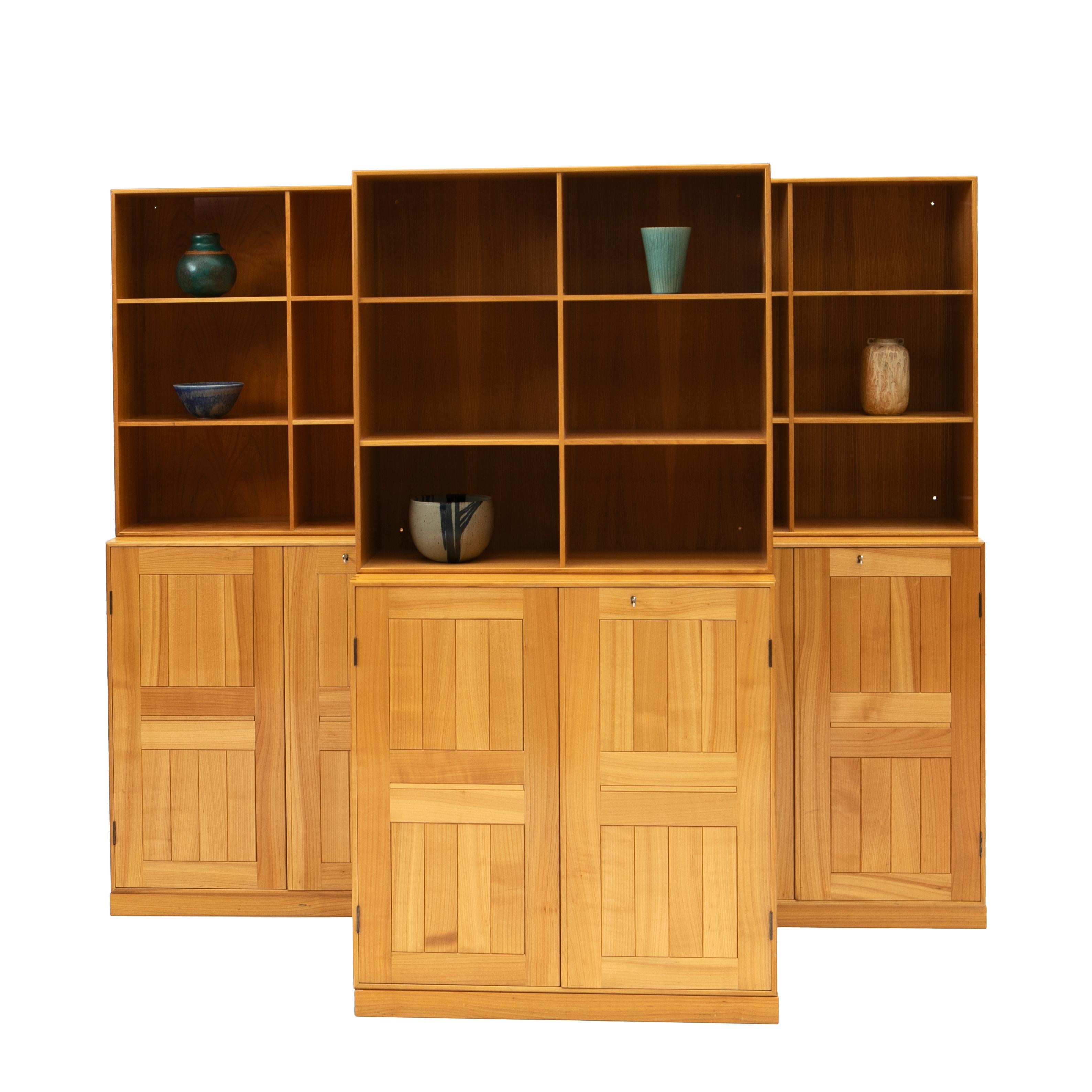 Mogens Koch, 1898-1992,.

Mogens Koch storage system in ash manufactured by Rud. Rasmussen, 1960's.
Set of three cabinets and three bookcases in patinated solid elm on three bases. Reverse with paper labels.
In untouched good condition with a