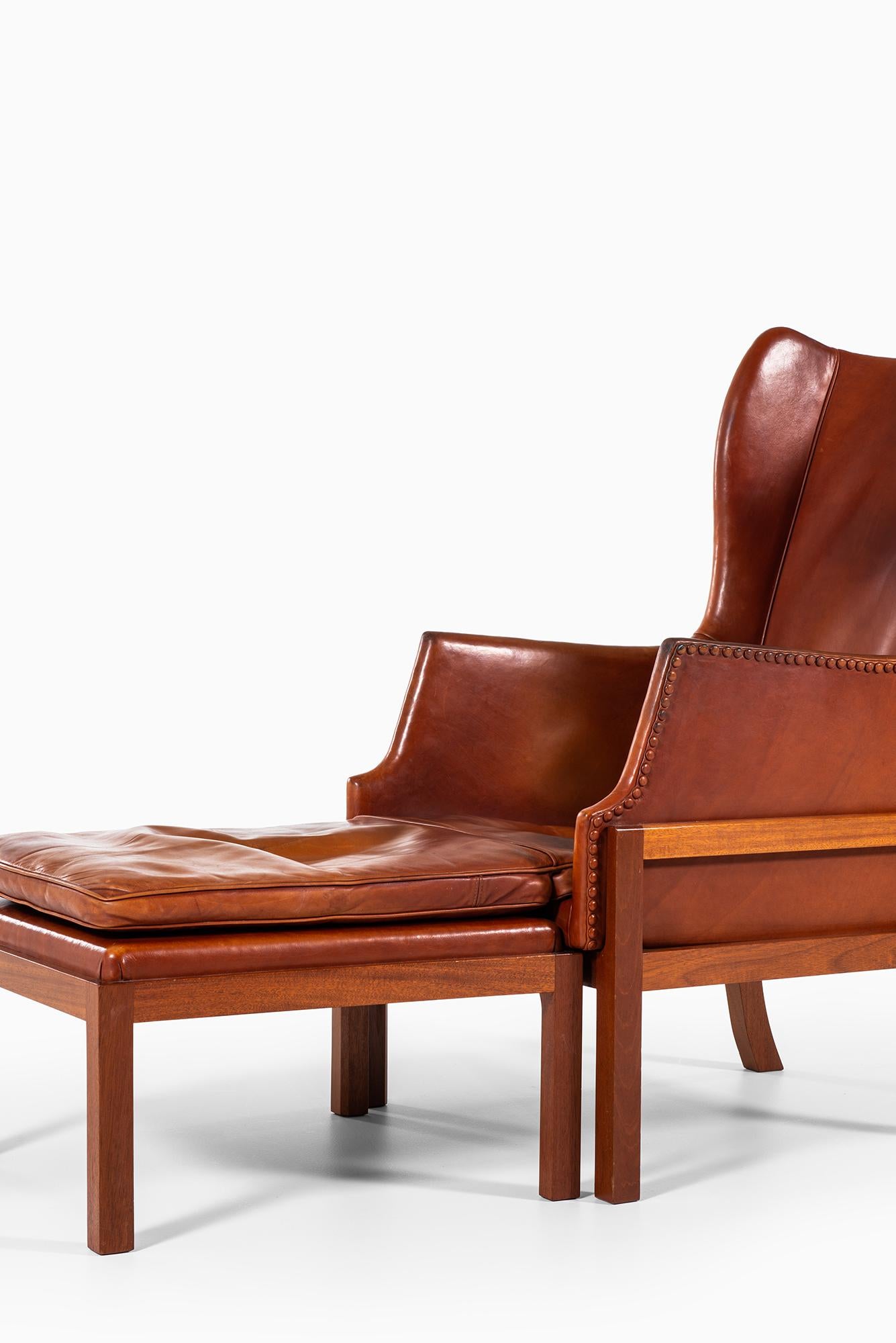 Very rare wingback easy chair with stool designed by Mogens Koch. Produced by cabinetmaker Rud Rasmussen in Denmark.