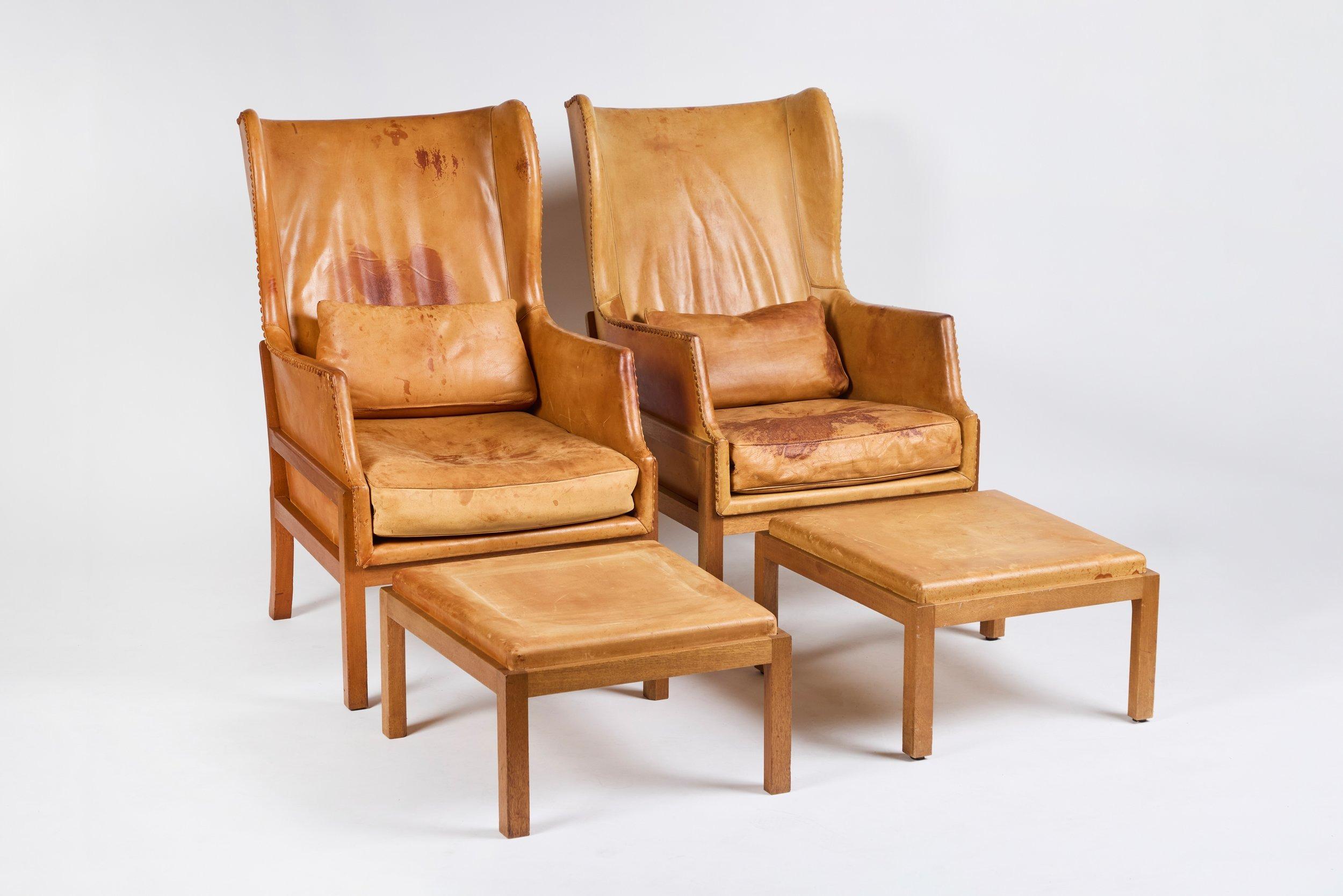 Pair of Mogens Koch Wingback Chairs and Ottomans. Leather buttons and cushions.  Mogens Koch for K. Ivan Schlechter, 'fireside' wingback lounge chair and ottoman, model MK50, mahogany, leather, Denmark, design 1936, production 1964-1979. Mogens