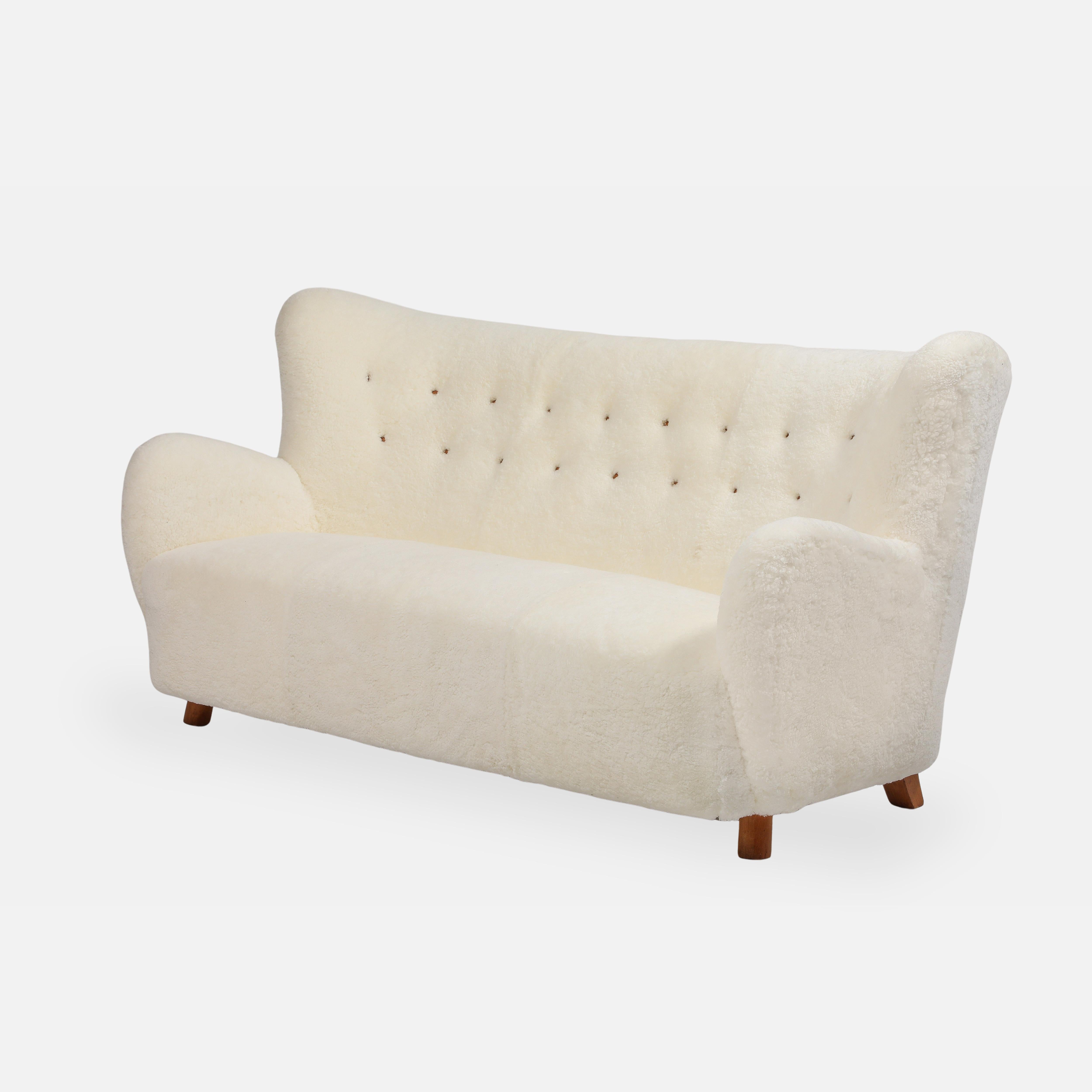 Precioso sofá escandinavo moderno Mogens Lassen en bouclé marfil con respaldo ligeramente curvado y copetudo y reposabrazos curvados sobre patas de madera de haya teñida arqueada. Este icónico sofá modernista danés de la década de 1940 es un modelo