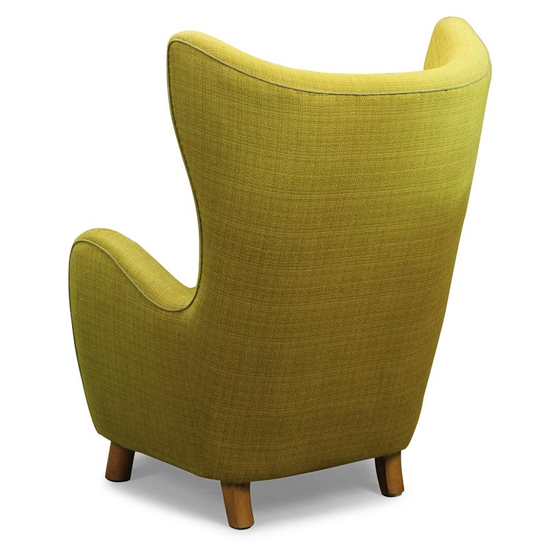 Mogens Lasse style - High-Backed lounge chair

The high-backed wing chair, manufactured by Danish Furniture Producer has minimalistic curved armrests and the typical round, wooden beech legs. 
The seat cover is upholstered with a beautiful green