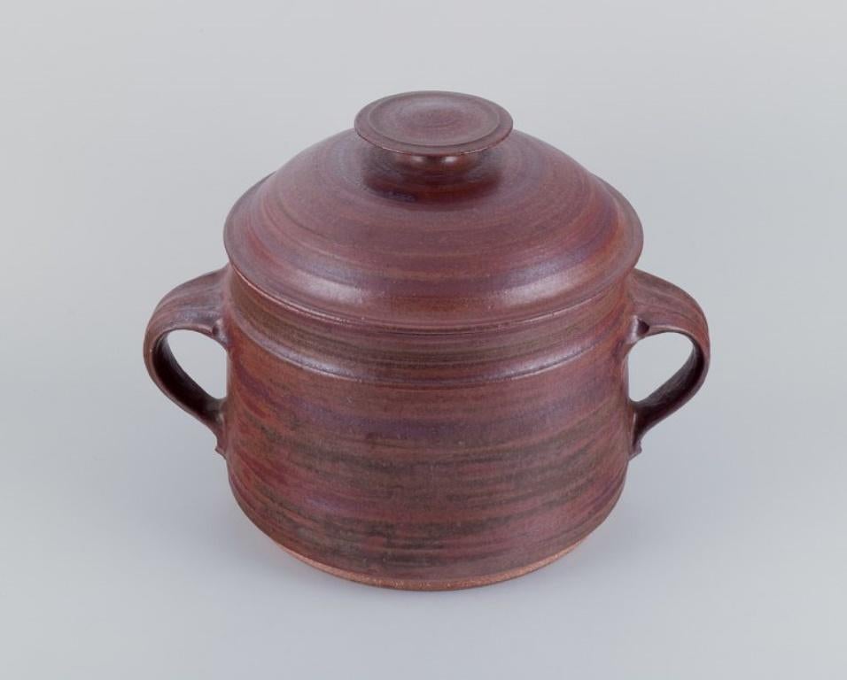 Mogens Nielsen, Nysted, Denmark.
Colossal handmade lidded jar in ceramic with glaze in brown tones.
1978.
Signed.
In perfect condition.
Dimensions: Diameter 32.5 cm including handles, Height 25.0 cm.