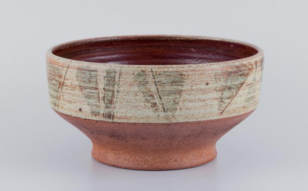 Mogens Nielsen, Nysted, Denmark.
Large handmade ceramic bowl decorated with abstract motifs. 
Glazed in brown tones.
1978.
Signed.
In perfect condition.
Dimensions: Diameter 27.6 cm, Height 14.0 cm.