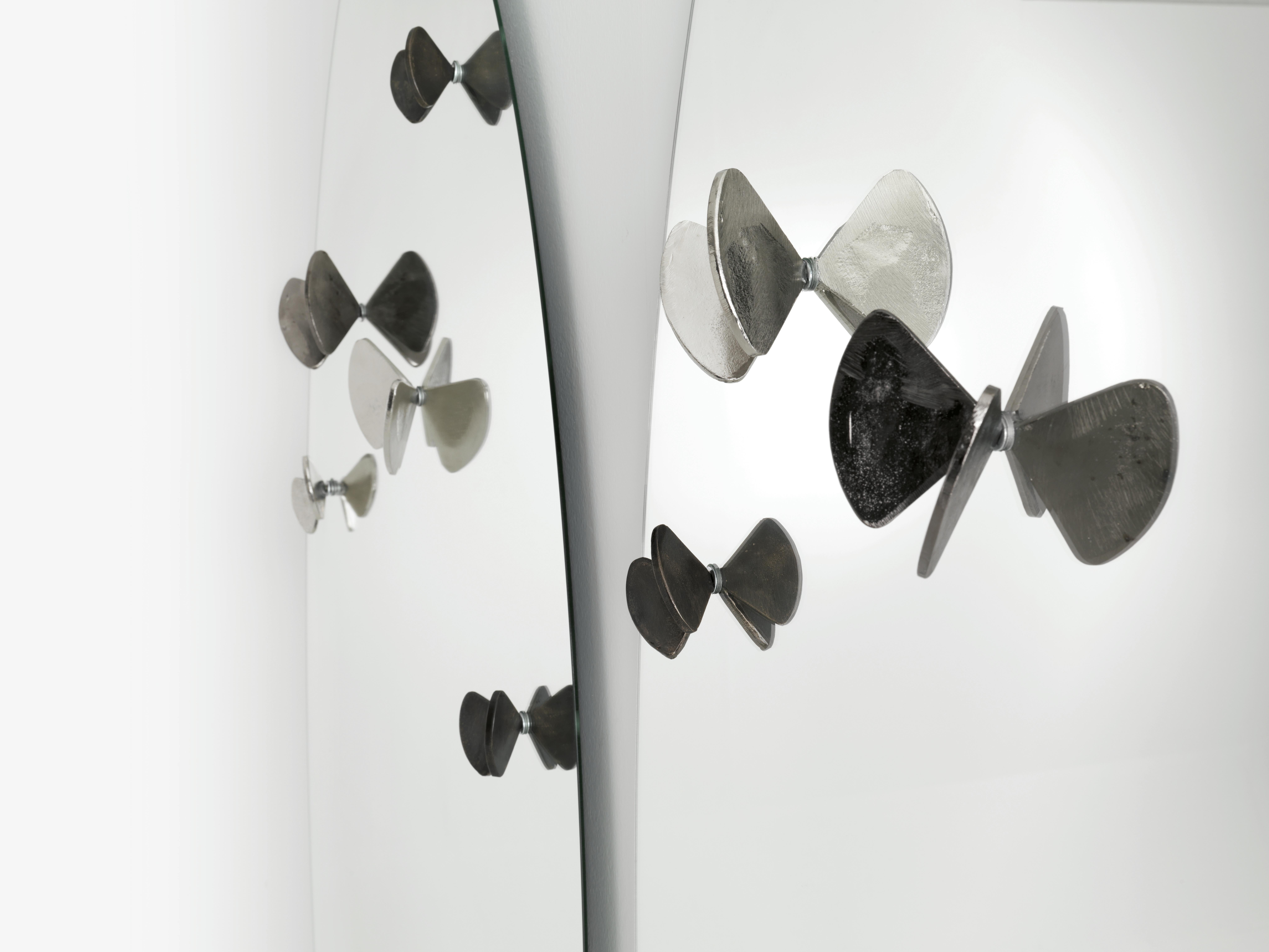 Miroir Bice avec papillons en fonte de laiton conçu par Roberto Mora pour la marque Mogg.  Des papillons supplémentaires peuvent également être achetés avec deux tailles différentes. Les papillons sont disponibles en finition cuivre ou nickel.

Bice