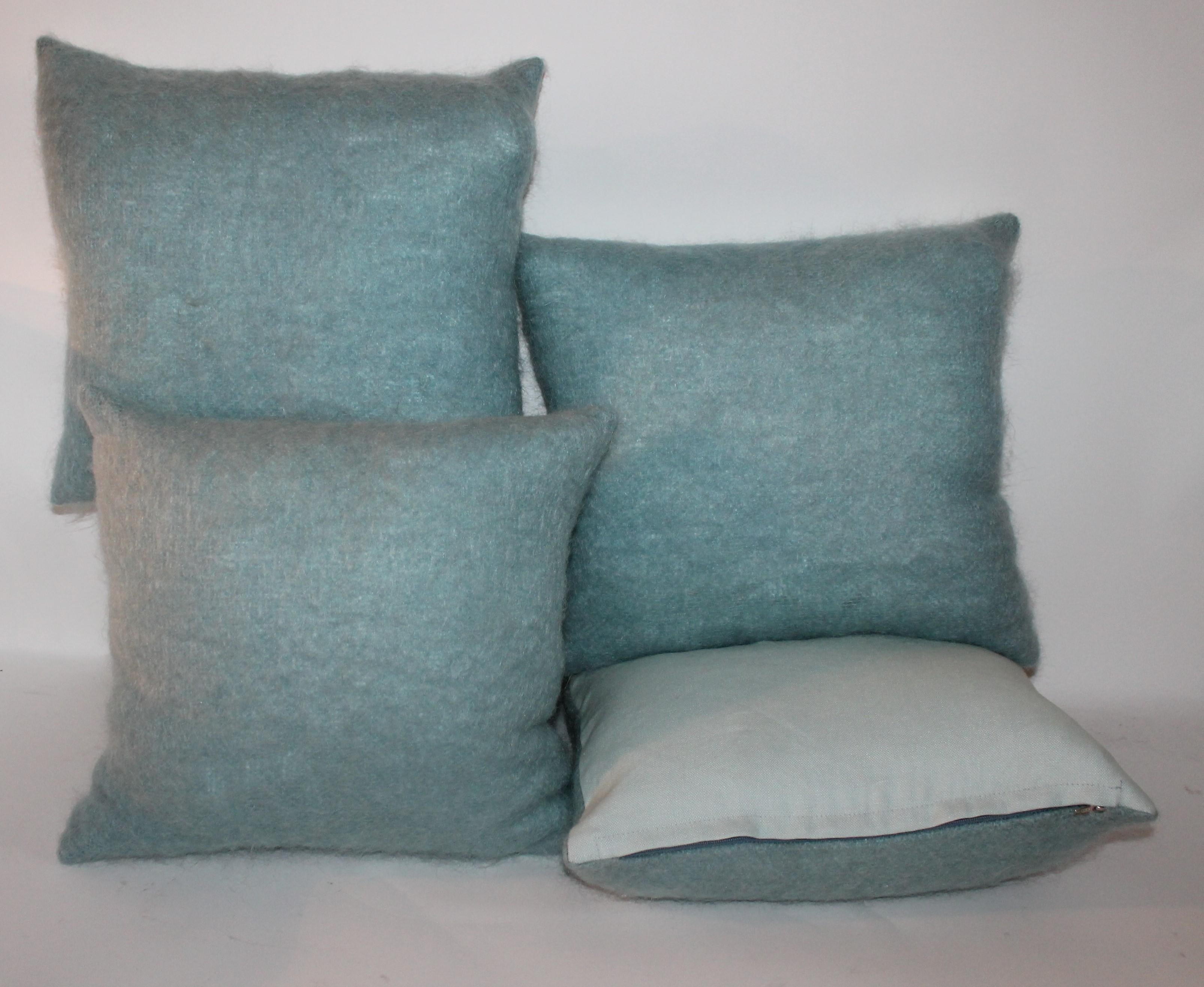 These fine robin egg blue mohair pillows have light blue cotton linen backings. The inserts are down and feather fill. Sold as collection of four.