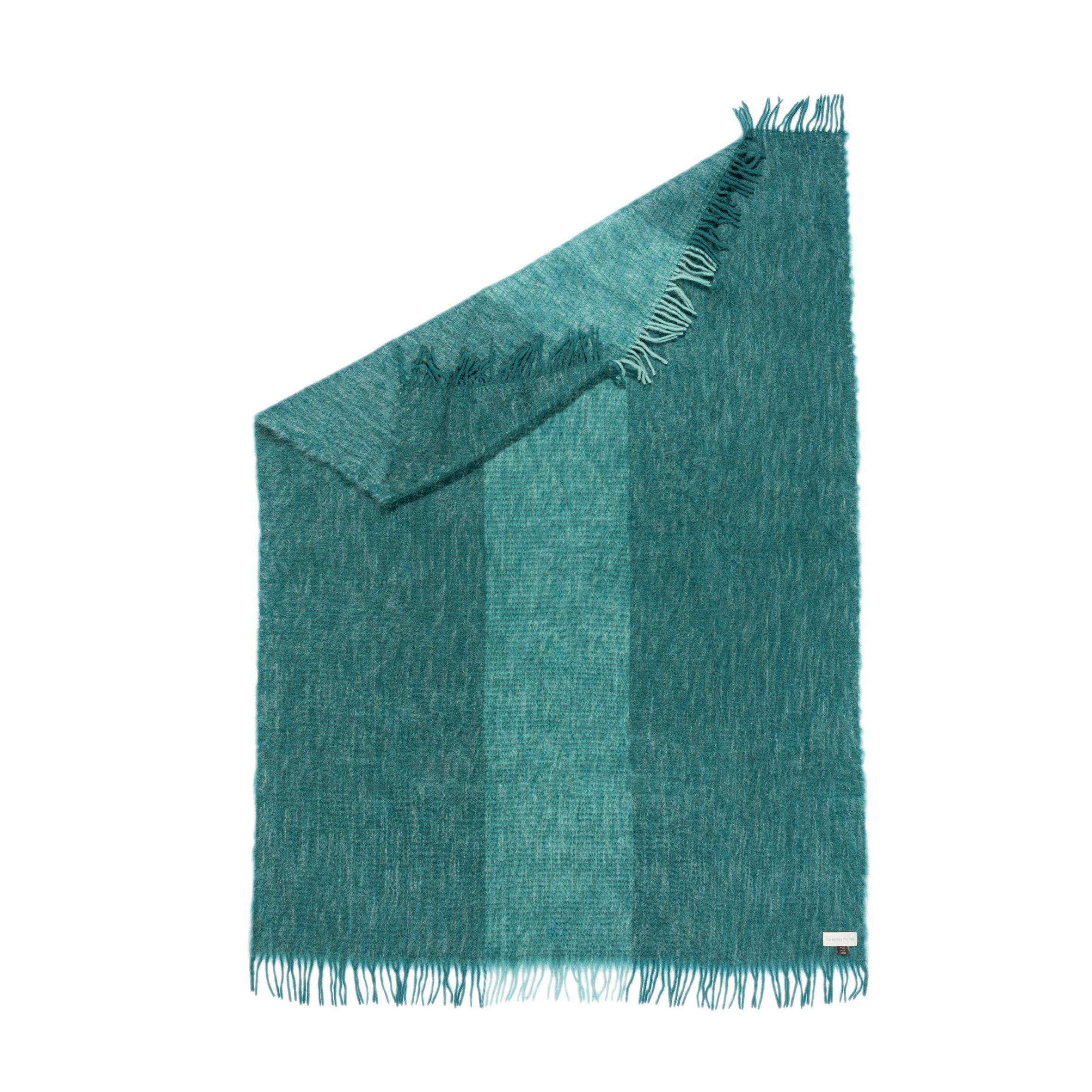 Designed in Berlin by Catharina Mende, woven of 50% mohair, 48% Wool, 2% polyamide in Spain: This Petrol flattering and warming fluffy mohair blanket is the perfect companion for every season - an indispensable favorite for the home or the