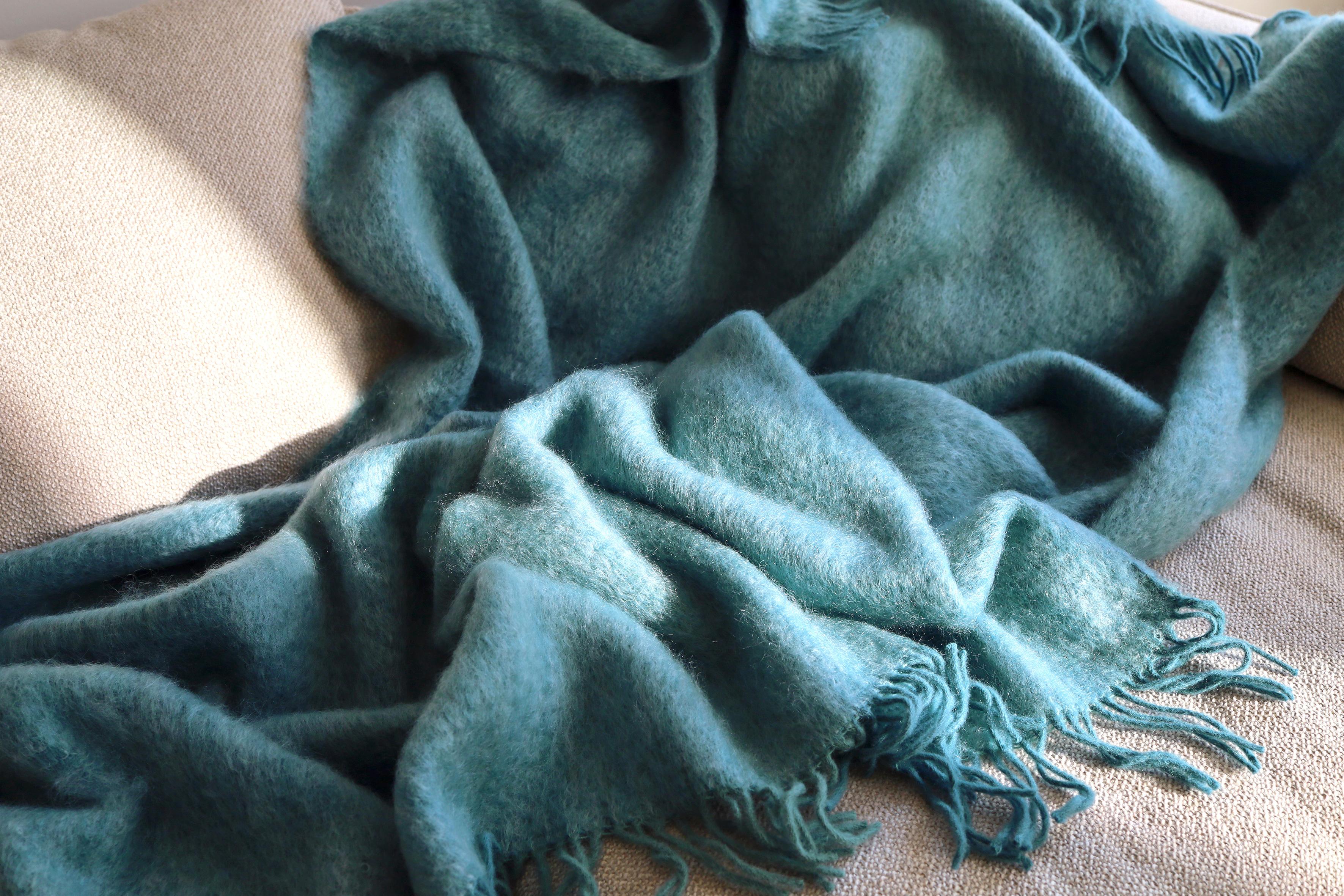 Designed in Berlin by Catharina Mende, woven of 50% mohair, 48% Wool, 2% polyamide in Spain: This Turquoise flattering and warming fluffy mohair blanket is the perfect companion for every season - an indispensable favorite for the home or the