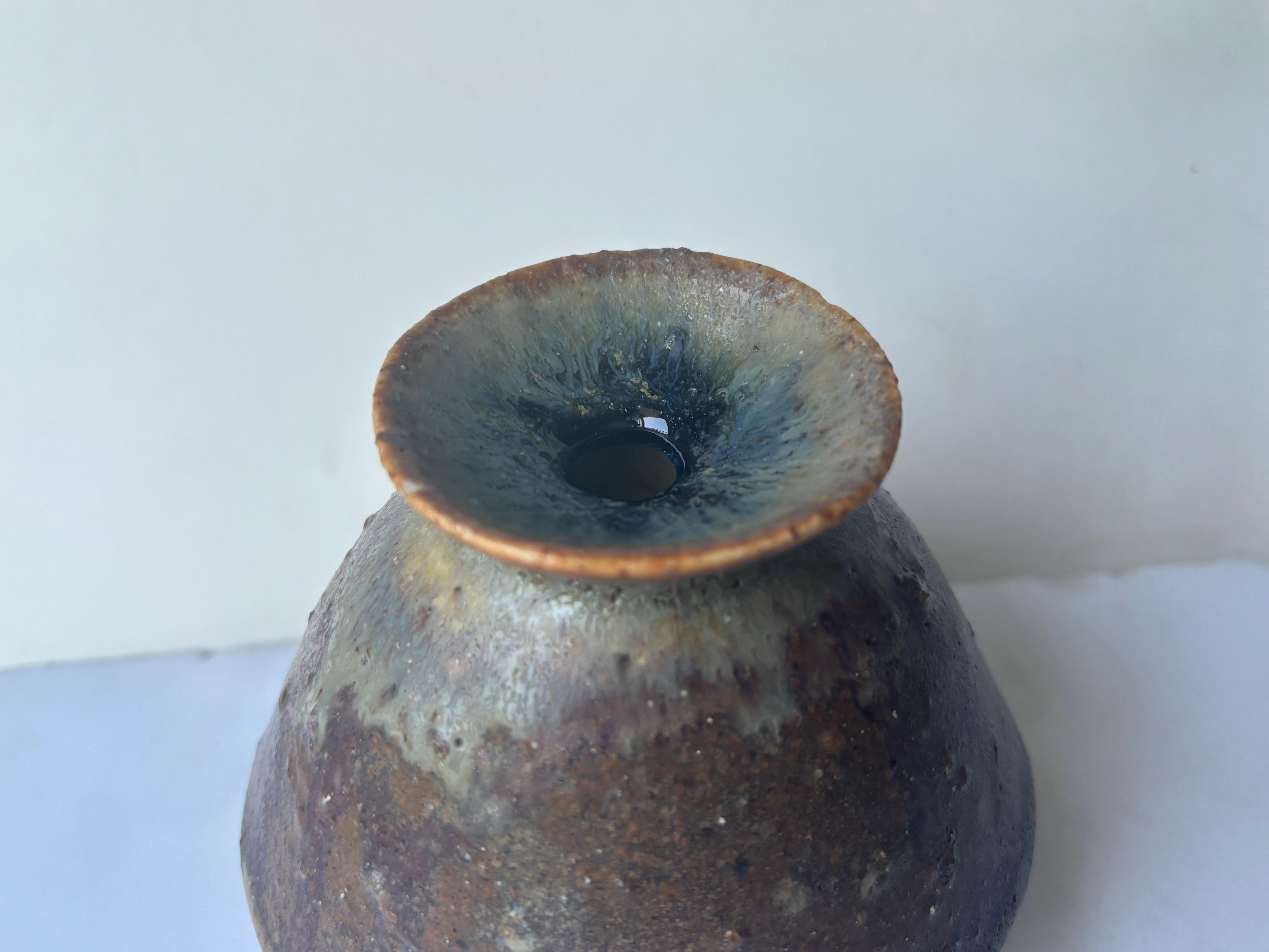 Si tratta di un vaso molto interessante con quello che sembra essere uno smalto di vetro sulla parte superiore blu. Questo vaso ha l'aspetto di un doppio cono o addirittura di un fungo. O vaso con gonna. Questo vaso è firmato con la sua tradizionale