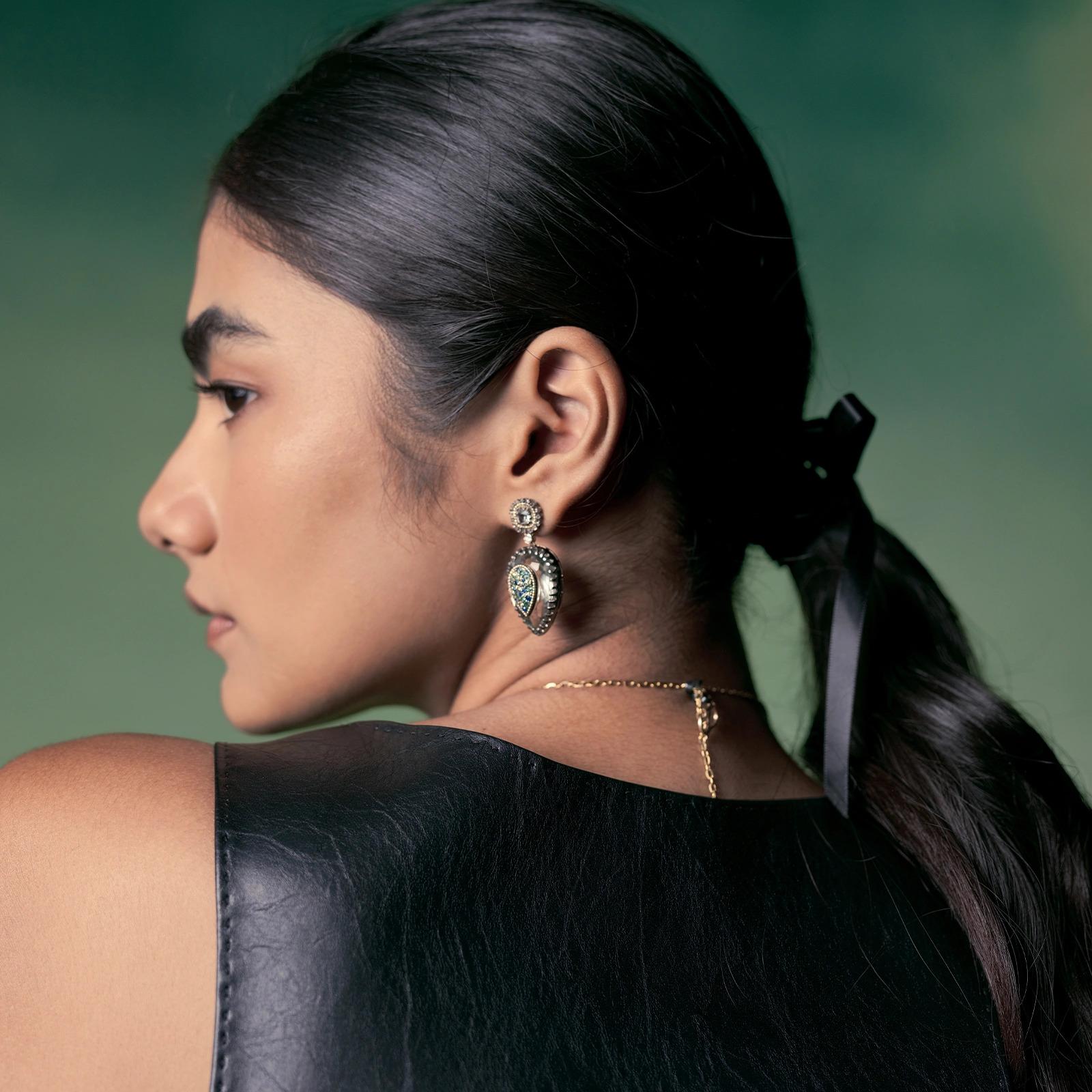 Clara è una bellissima giustapposizione di colori e brillantezza. Il cuore è costituito da una deliziosa ametista verde, da grappoli di zaffiri e tsavorite che rubano i riflettori sospesi da un'aureola di diamanti taglio rosa che circonda