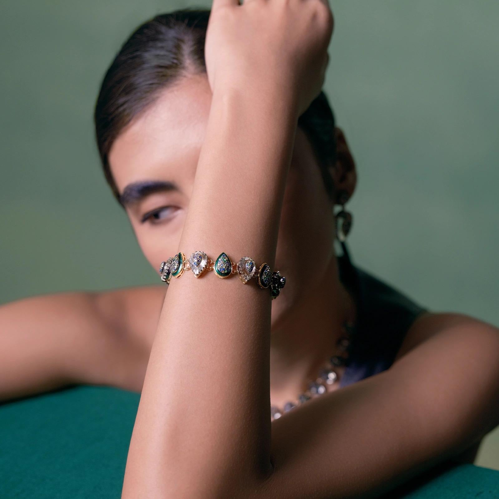 Das Armband Clara ist ein exquisites Stück, das sowohl für den Abend als auch für jeden Tag geeignet ist. Das Armband besteht aus mehreren Birneneinheiten, die mit grünen Amethysten besetzt sind, sowie aus Saphiren und Tsavoriten, die asymmetrisch