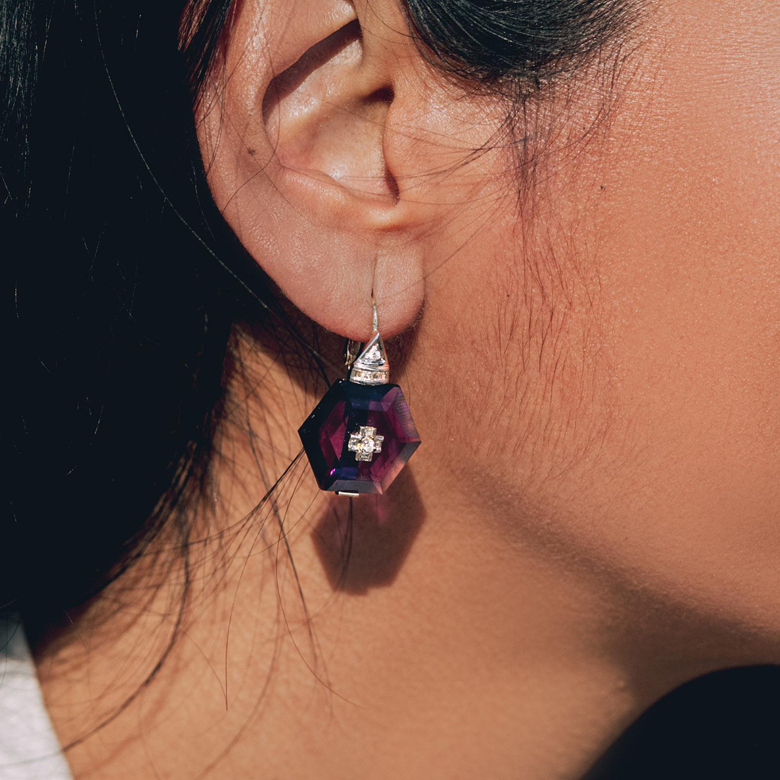 These earrings boast of a nano purple amethyst at their center held by a gold base and pierced with a diamond-studded motif. The nano-amethysts are held by a diamond-studded unit attached to a lever-back closure.

Gold(14K) : 4.0g
Brilliant cut