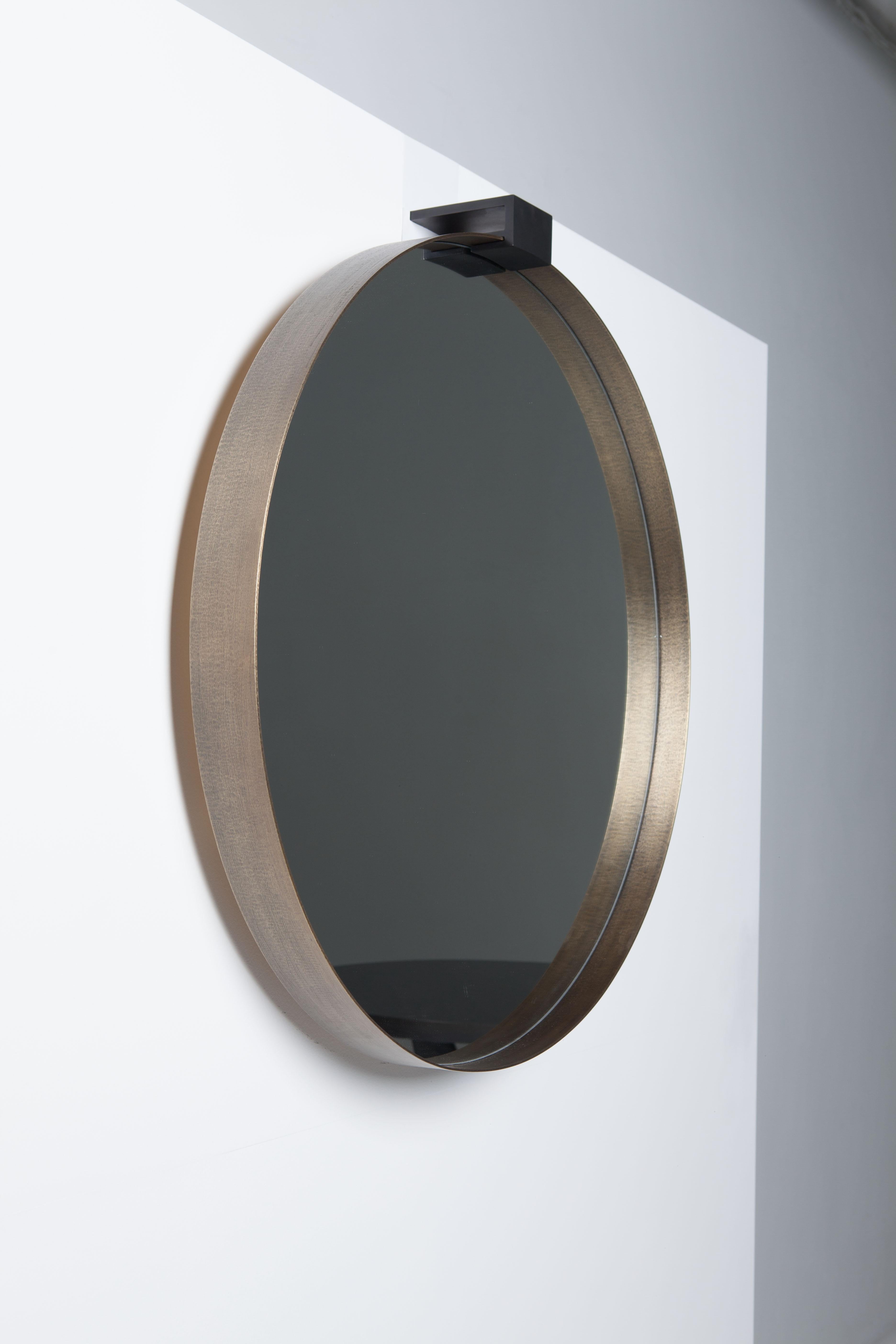 Moi round mirror with a hand-crafted textured aged brass. 
The frame support is bronzed steel and can either be inserted into the wall, completely concealed or surface mounted. Screws will be visible if surface mounted. 

The brass frame projects 2