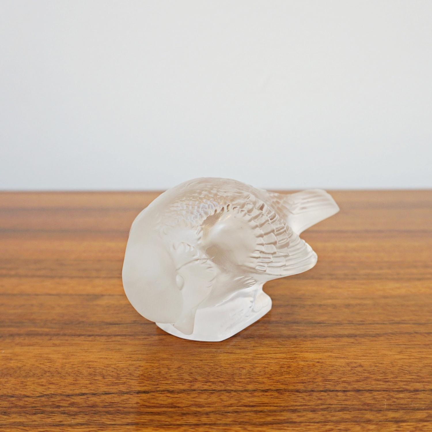 Moineau Sournois, an Art Deco glass bird paperweight. A frosted glass figure of a sparrow pecking for food. Model number 1166.  Stencil etched R Lalique France to underside

iterature: Marcilhac, R Lalique Catalogue Raisonné de L’Œuvre de Verre