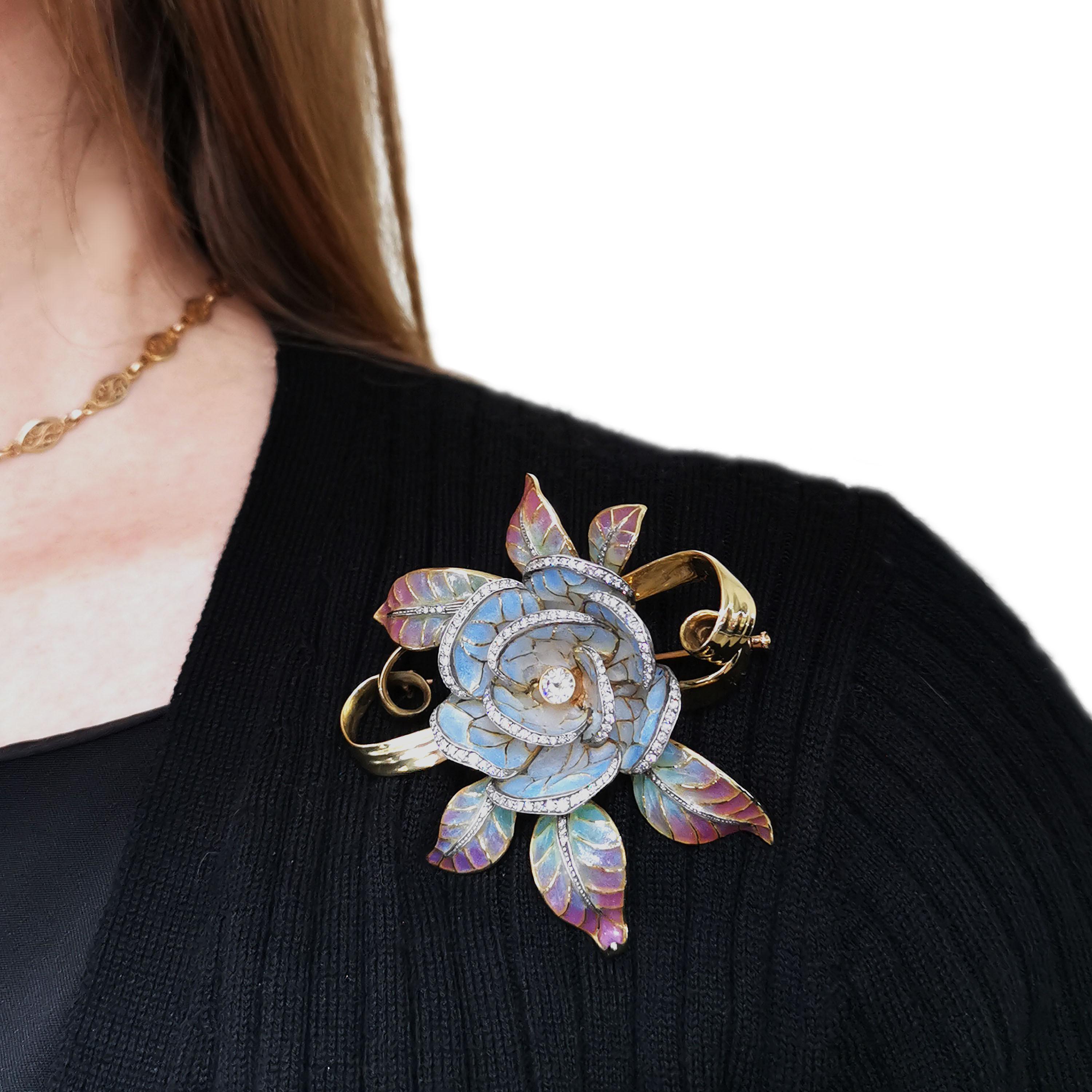 A Moira flower head brooch with blue, pink, green and white plique à jour enamel and diamonds, with a rub over set round brilliant-cut diamond in the centre of a shaded blue to white plique à jour enamel flower, with eight-cut diamonds pavé set in