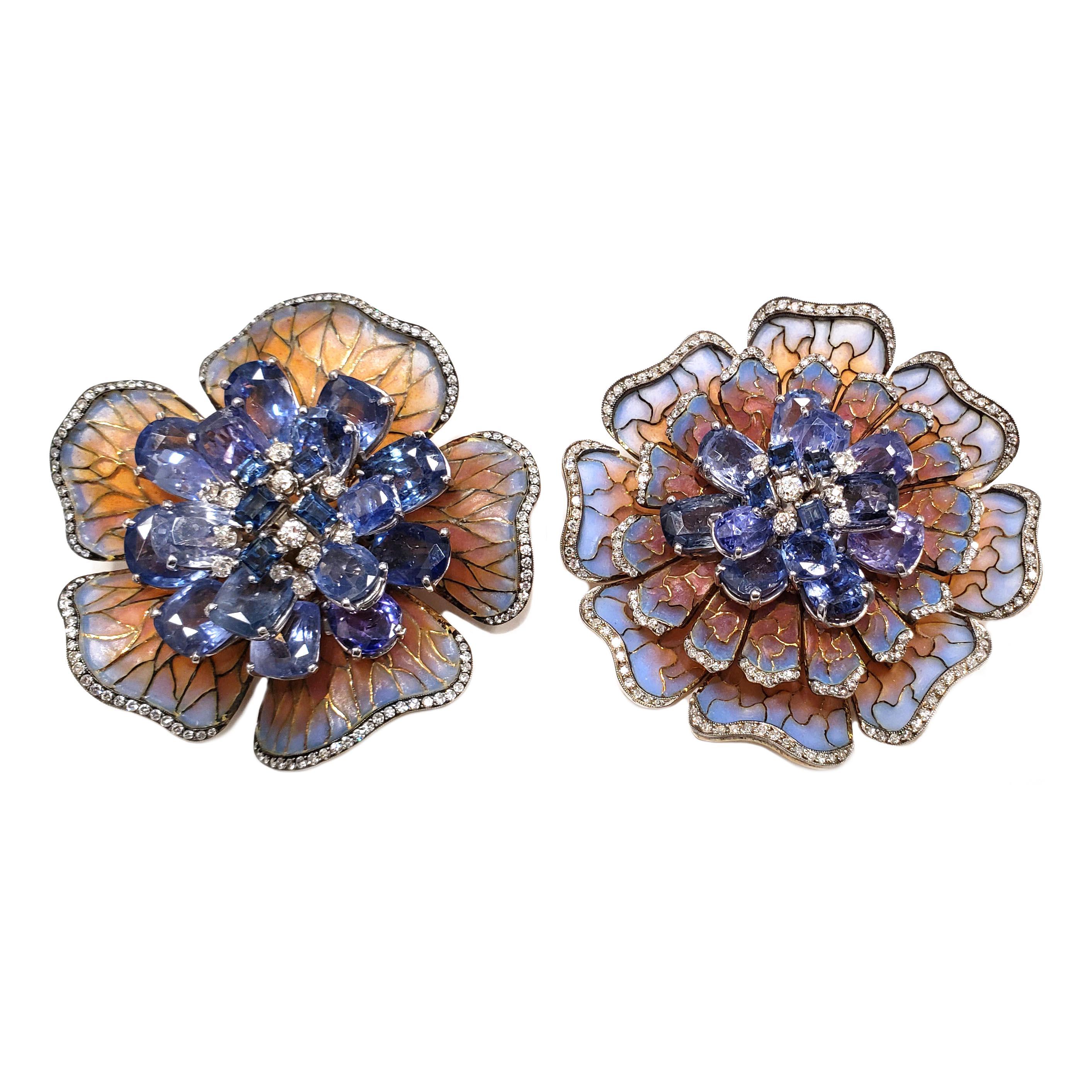 Beautiful pair of sapphire and diamond flower Plique-à-jour pins/ brooches by Moira. The pins are in excellent condition. There is an estimated total weight 84.00 carats in sapphires. One pin has an estimated 50.00 carats in sapphires and the other