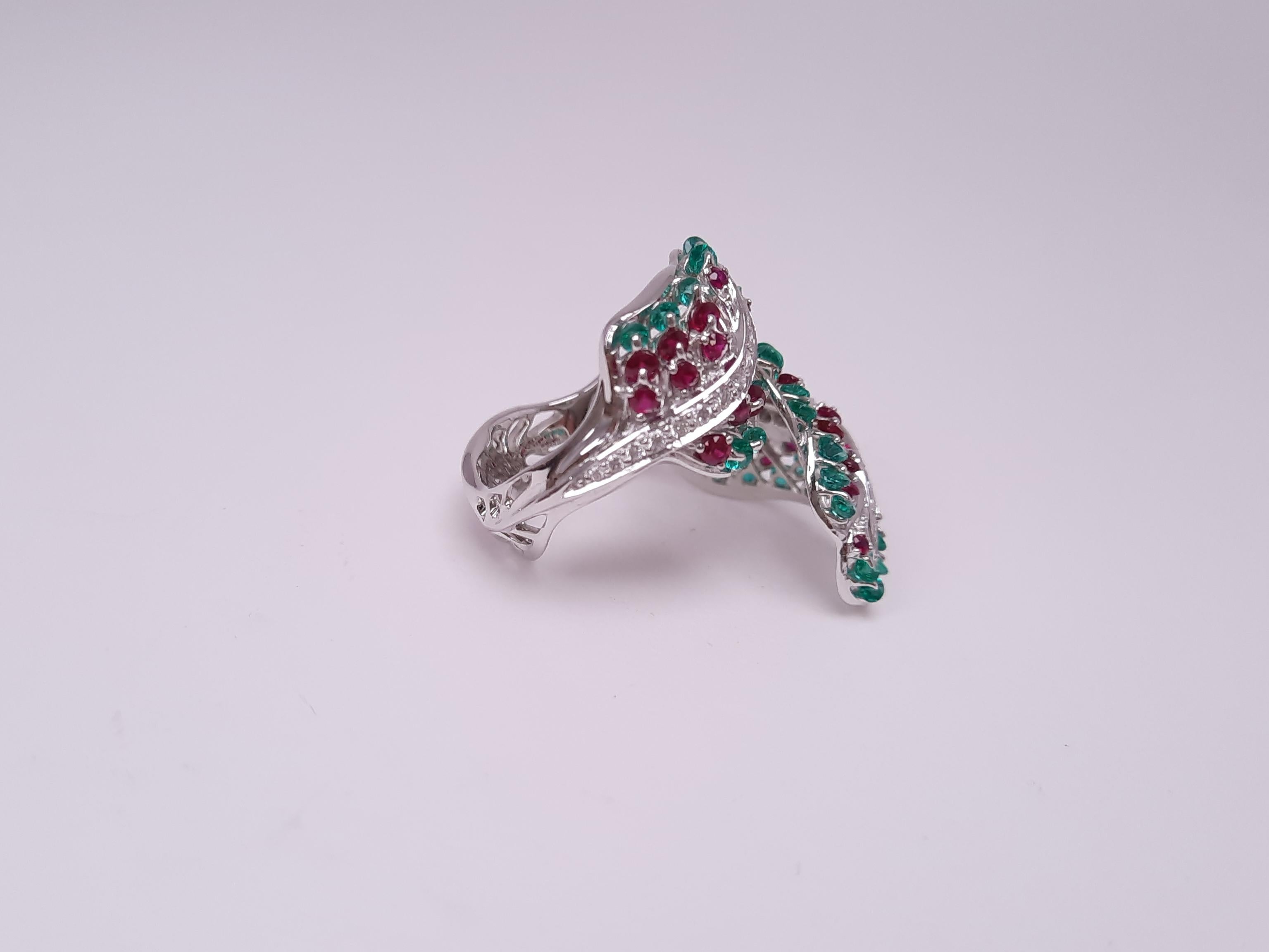 A fashionable yet graceful angel wing ring created by Viktor Moiseikin is  embedded with high quality rubies, emerald and a diamond belt gives a little accent. 

The stones are mounted in the innovative jewellery setting 