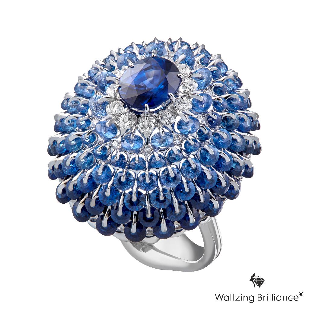 A deep blue sapphire is mounted in a state of the art design and technology. 

Internationally patented, Waltzing Brilliance technology is an innovative jewellery invention patented by Viktor Moiseikin, which a diamond facet gem is secured by two