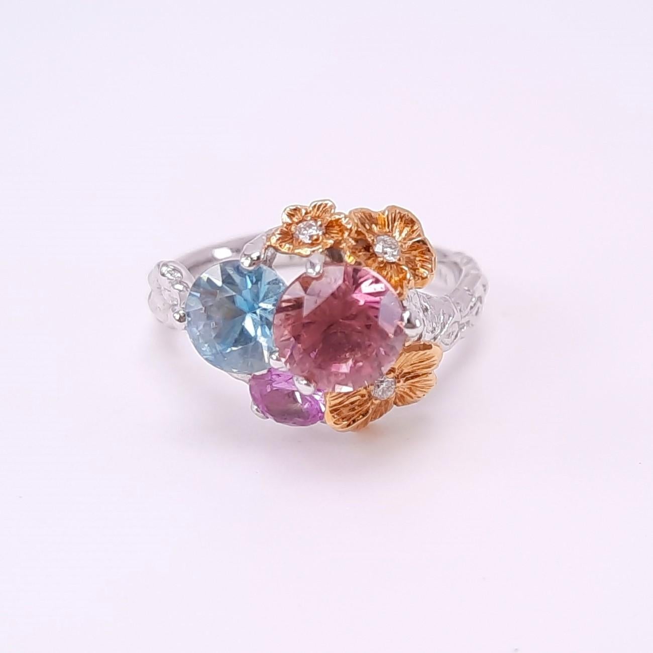 Handmade in 18K gold, Moiseikin's adorable floral ring gives mesmerising combination of pink tourmaline, blue zircon, diamonds, and fancy sapphires. Inspired by the delicate beauty of blooming flowers swaying in a fresh breeze, this ring captures
