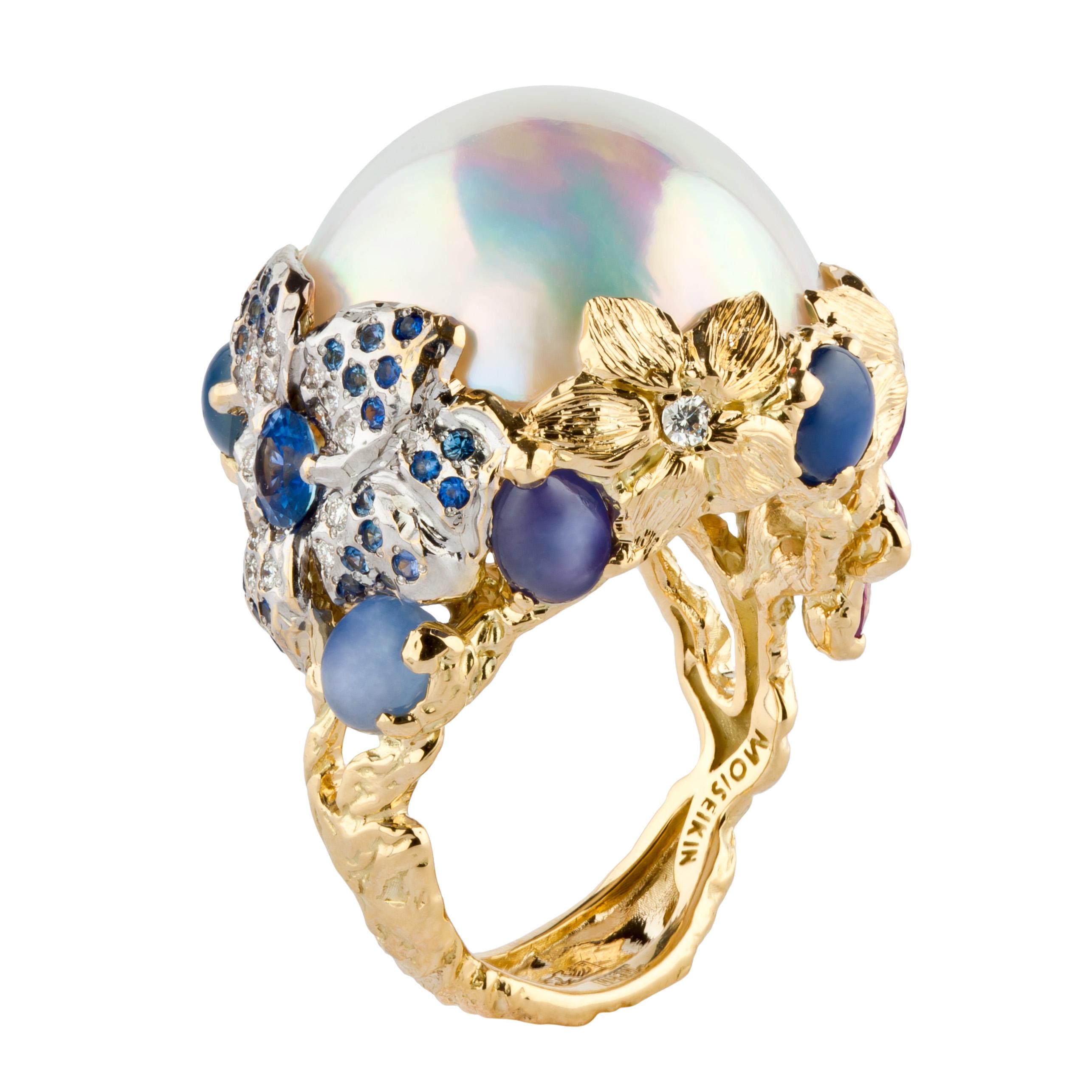 20mm size breath-takingly beautiful Mabe Pearl is artistically mounted in tender flower design decorated with cut blue sapphires, pink sapphires and star sapphires. The shimmer with a rainbow effect captures your eyes while  comforting your mood, 
