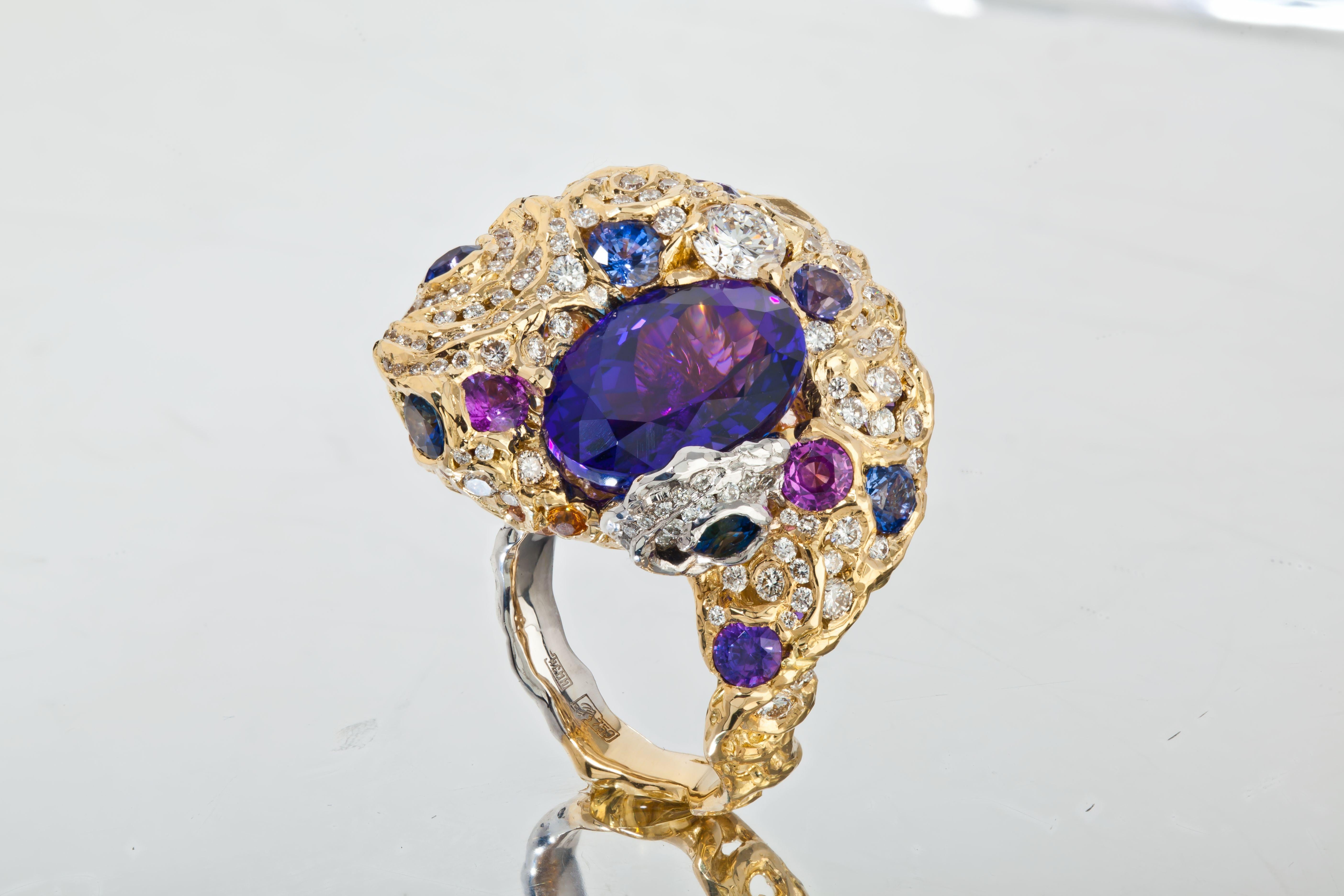 A deep colour 10 carat Tanzanite is artistically designed with 18 karat yellow gold,  1.71 carat diamonds and 5.97 carat fancy sapphire, making a swirling night sky. Wearing this handmade tri-dimensional ring, you will find different views and