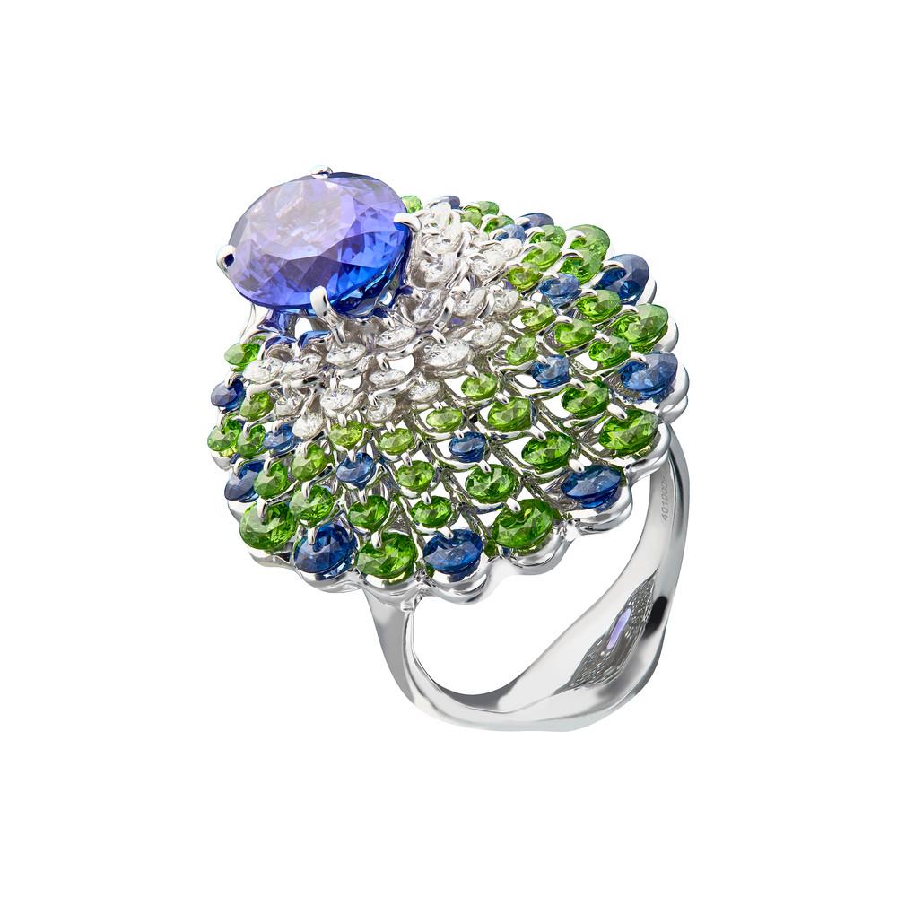 A vivid and clean 5ct Tanzanite is mounted in the innovative setting inspired by graceful peacock. Waltzing Brilliance technology is an innovative jewellery invention patented by Viktor Moiseikin, which a diamond facet gem is secured by two points:
