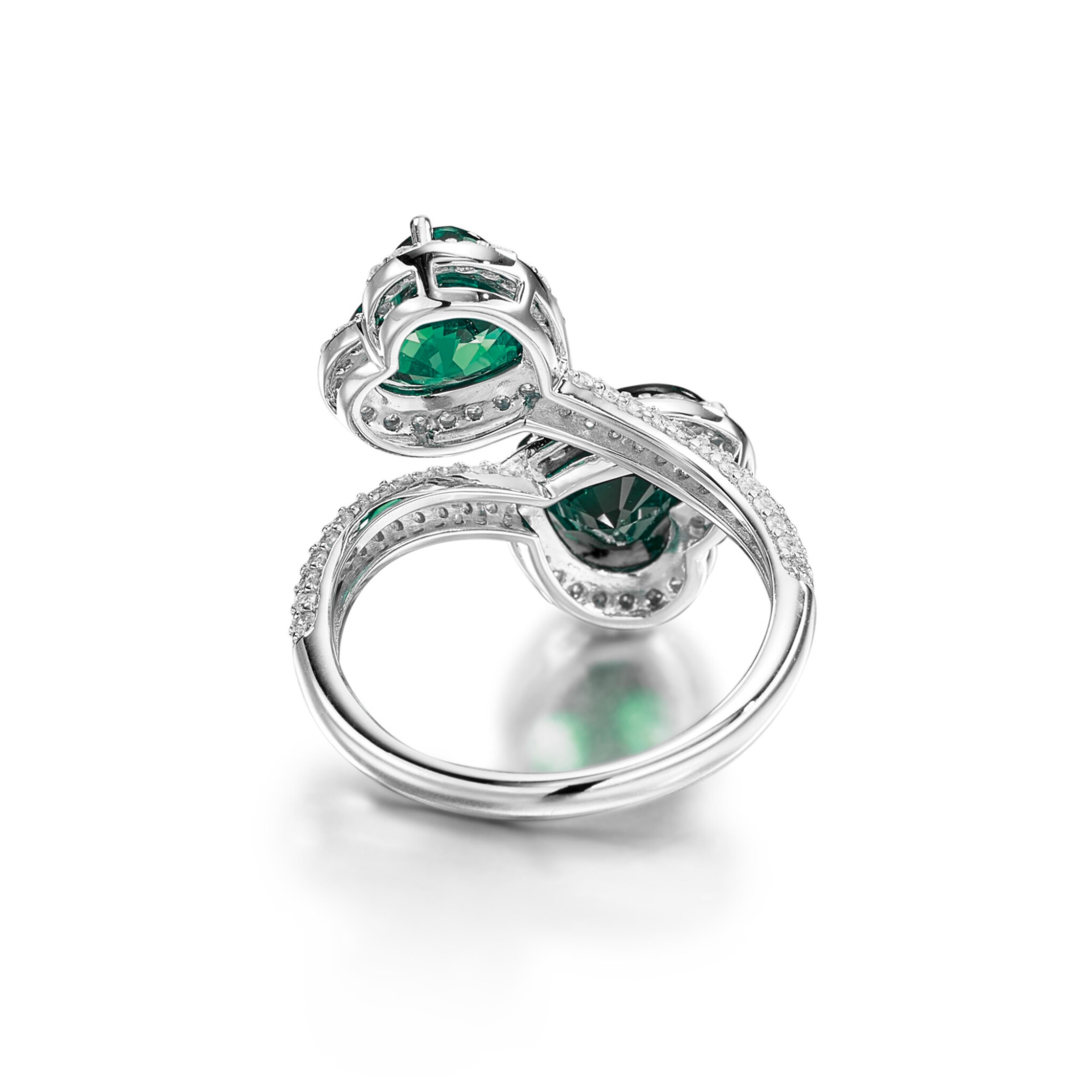 Dieser exquisite Ring ist eine zeitlose Kreation von Cecile Blake und zeigt einen leuchtenden 4-karätigen natürlichen Smaragd in Herzform. 

Die Smaragde sind umgeben von einem hübschen Pflaster aus runden Brillanten, die sorgfältig nach ihrer Farbe