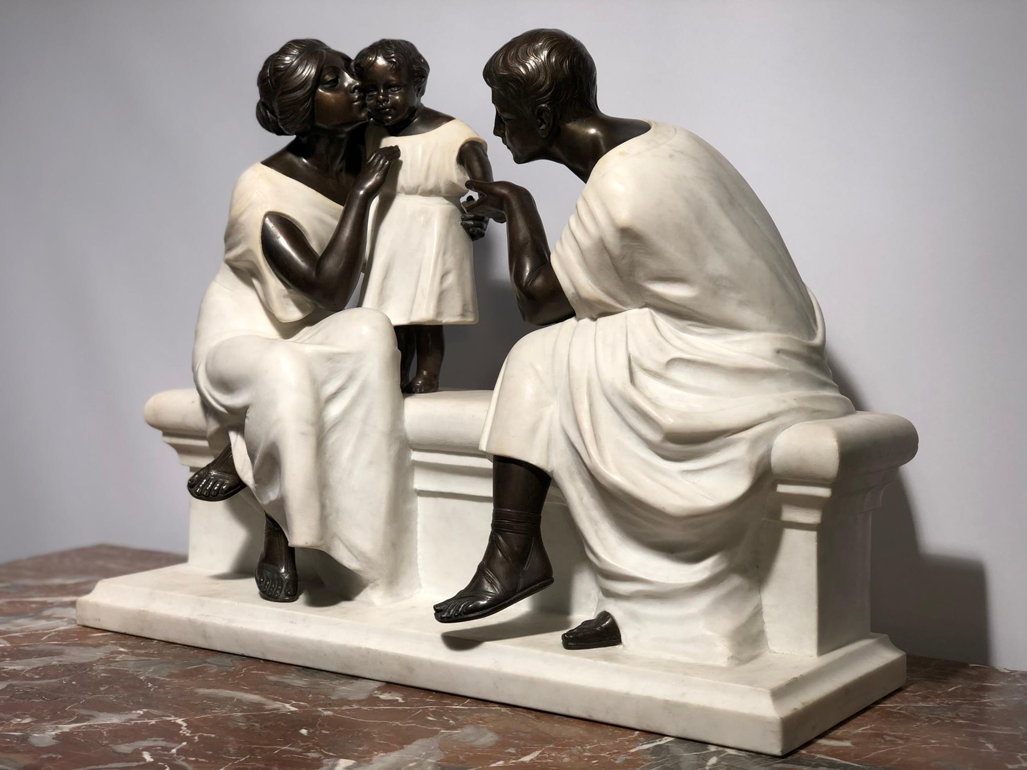 This sculpture is of rare beauty, a mixture of finely carved white marble and part in cast and chiseled bronze with a brown patina. The theme is presented as the love of parents towards their child. What could be more beautiful than to attend the
