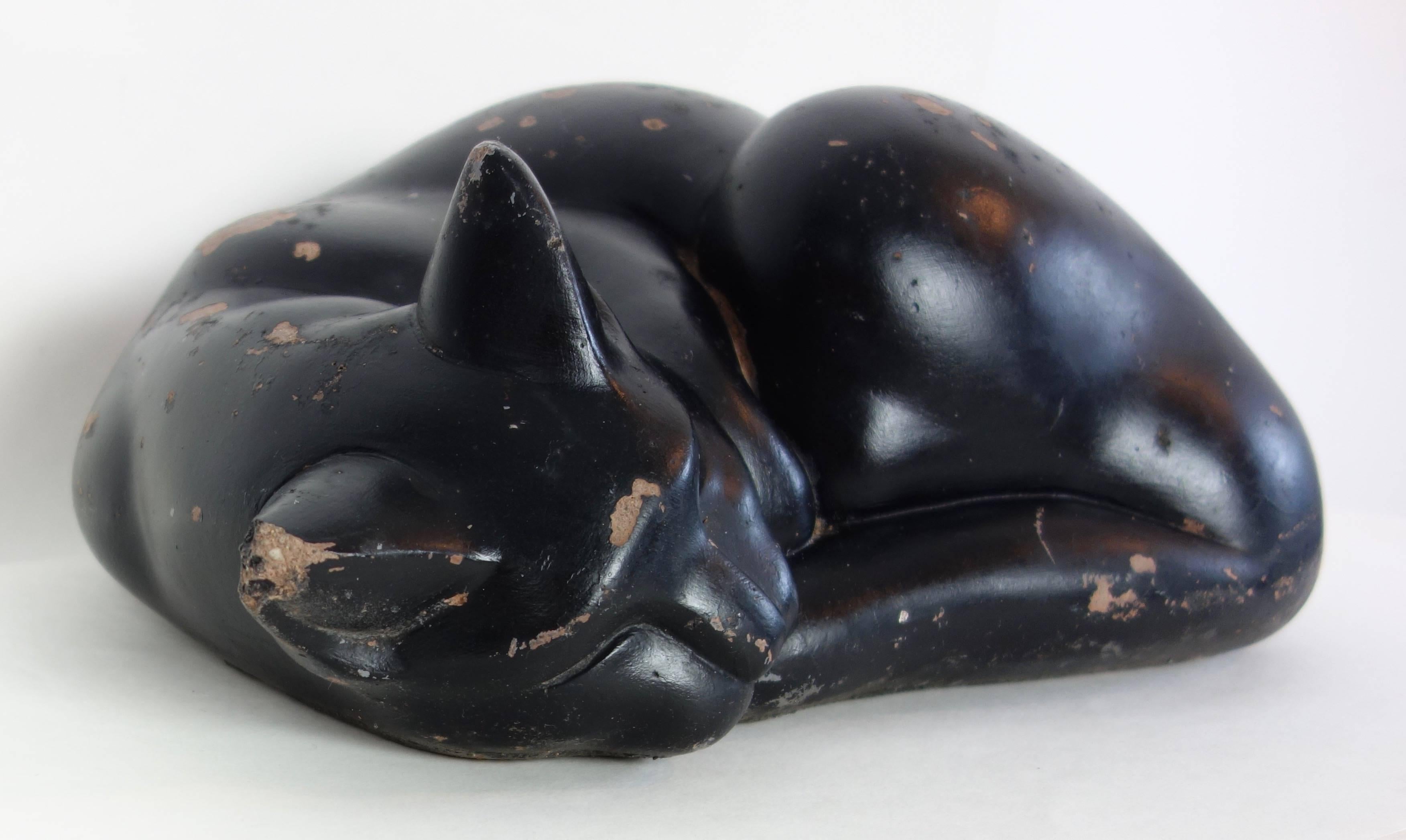 This is a wonderful molded concrete form of a sleeping black cat. Possibly used as a door stop, weighing almost 40 pounds.