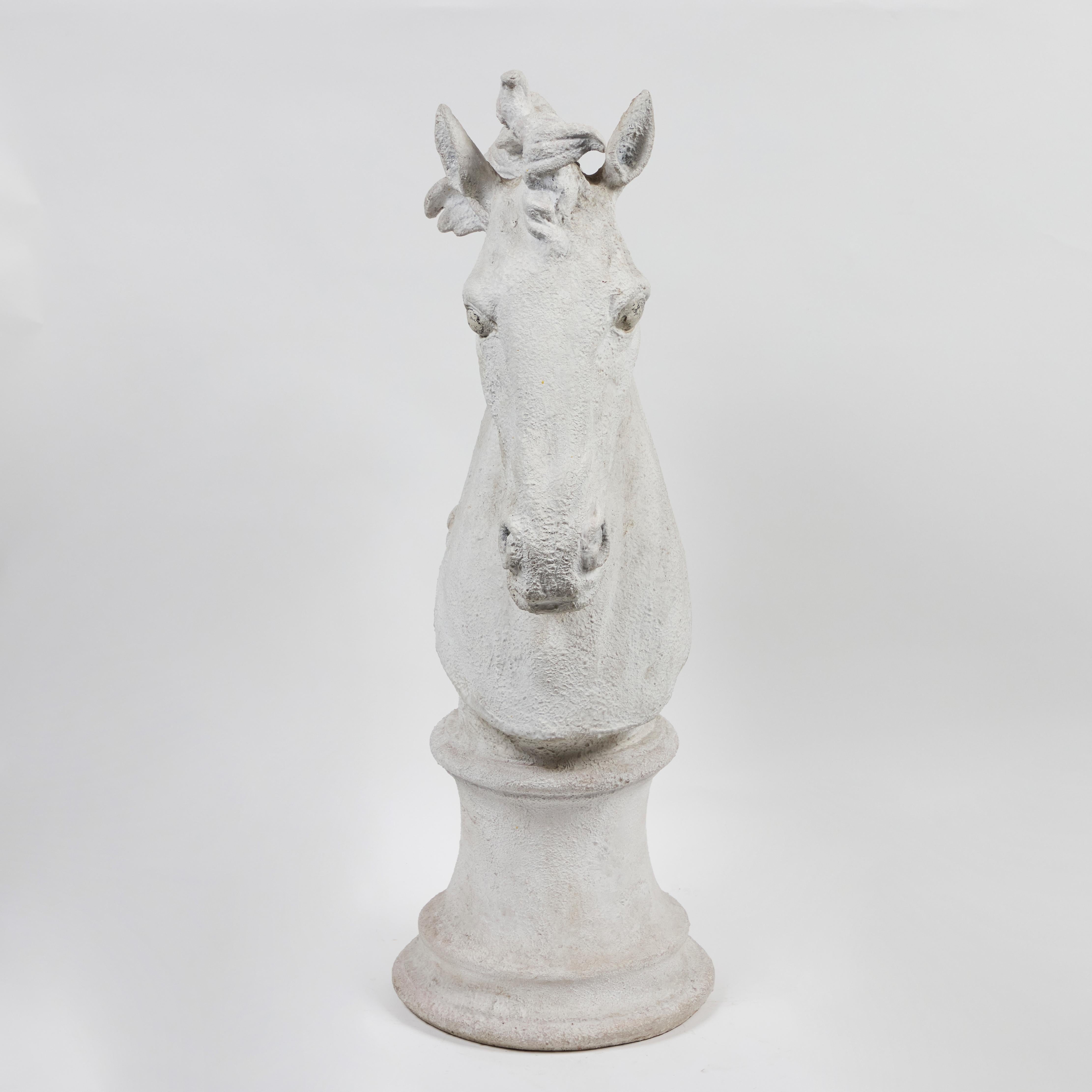 Escultura moldeada en gesso de la cabeza de un caballo sobre una base de 30 cm de diámetro.
