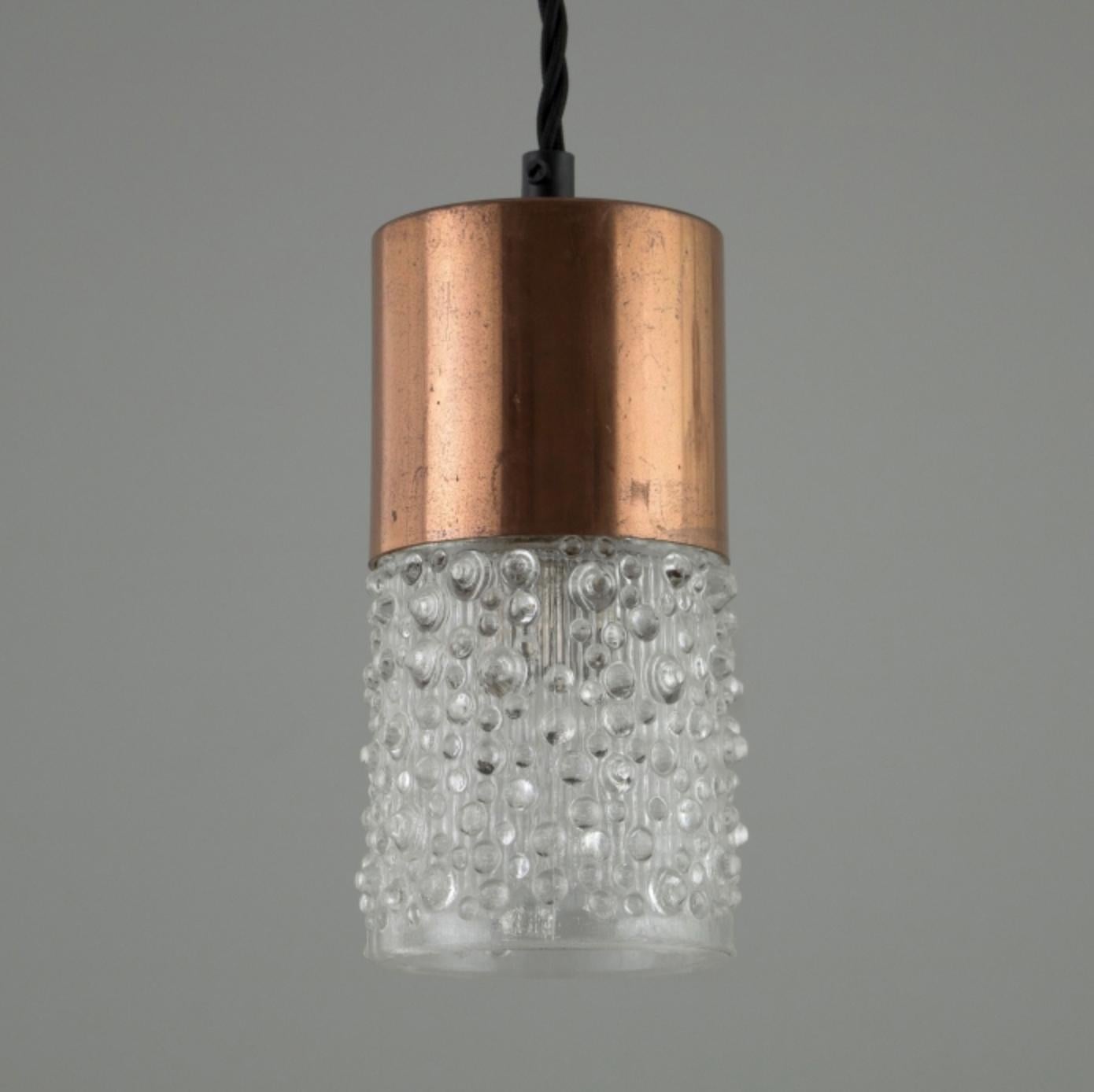 Large set stylish German pendants originally made in the 1960s. With a molded, open-bottomed glass shade and a copper plated/thermoplastic gallery. The contrasting glass and copper would make these lights a striking feature in any