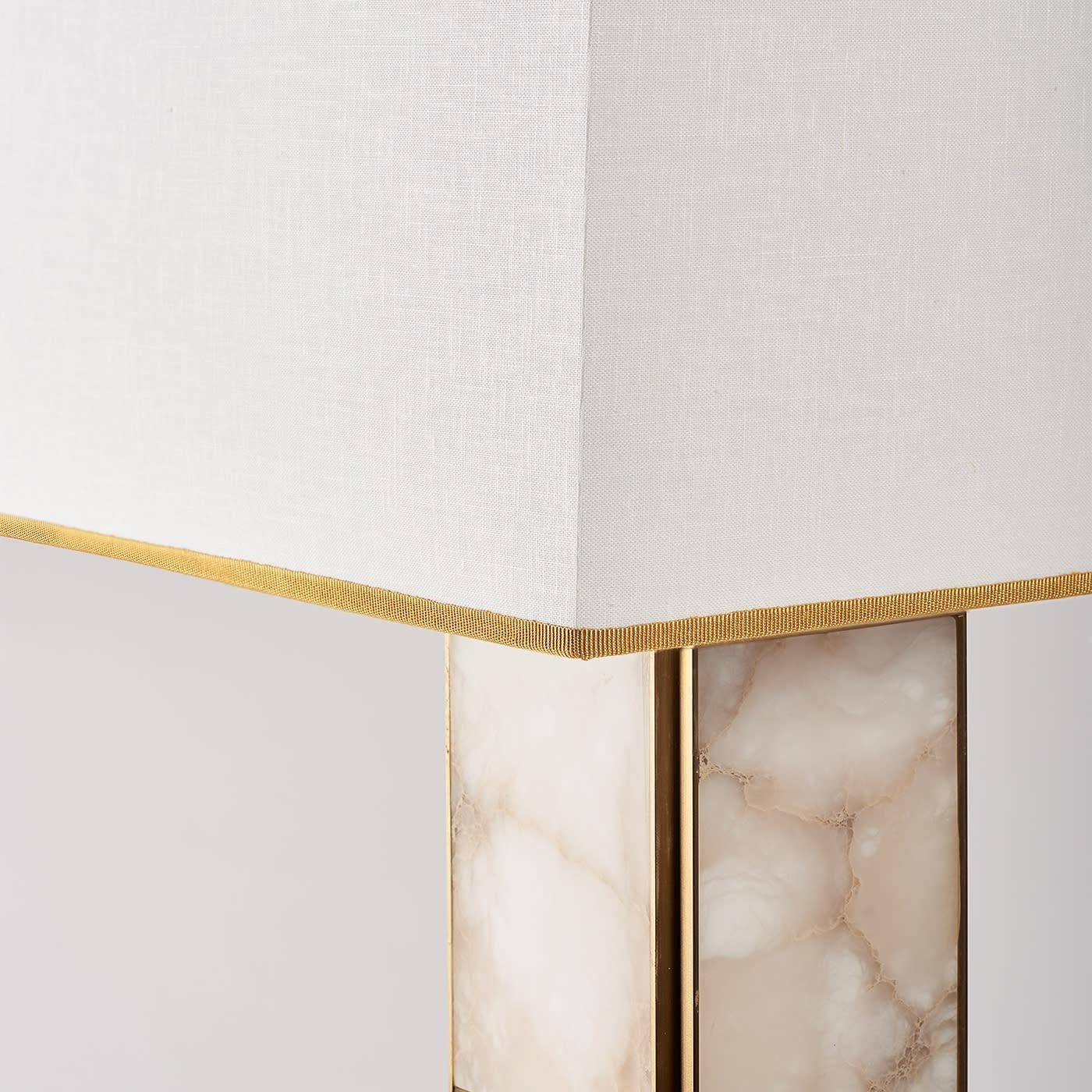 The Mole table lamp is characterized by a monolithic linear structure in brass and veined alabaster which gives it a modern and timeless aesthetic, perfect for different interior styles. Satin brass adds a touch of sophistication and warmth, while