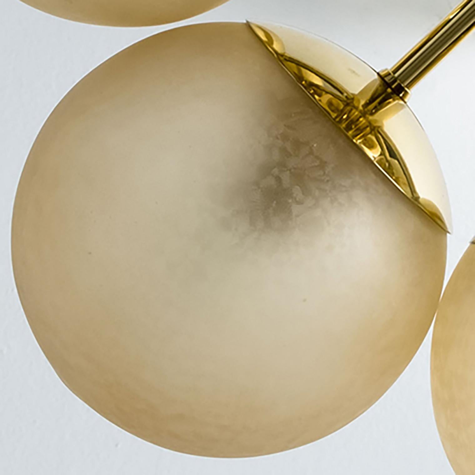 Magnifique lustre Kaiser à structure moléculaire. Un corps central en laiton est entouré de 6 globes soufflés à la main, étroitement attachés, en verre opalin de couleur ambre. Illumine magnifiquement.

Nettoyé, bien câblé et prêt à être utilisé. La
