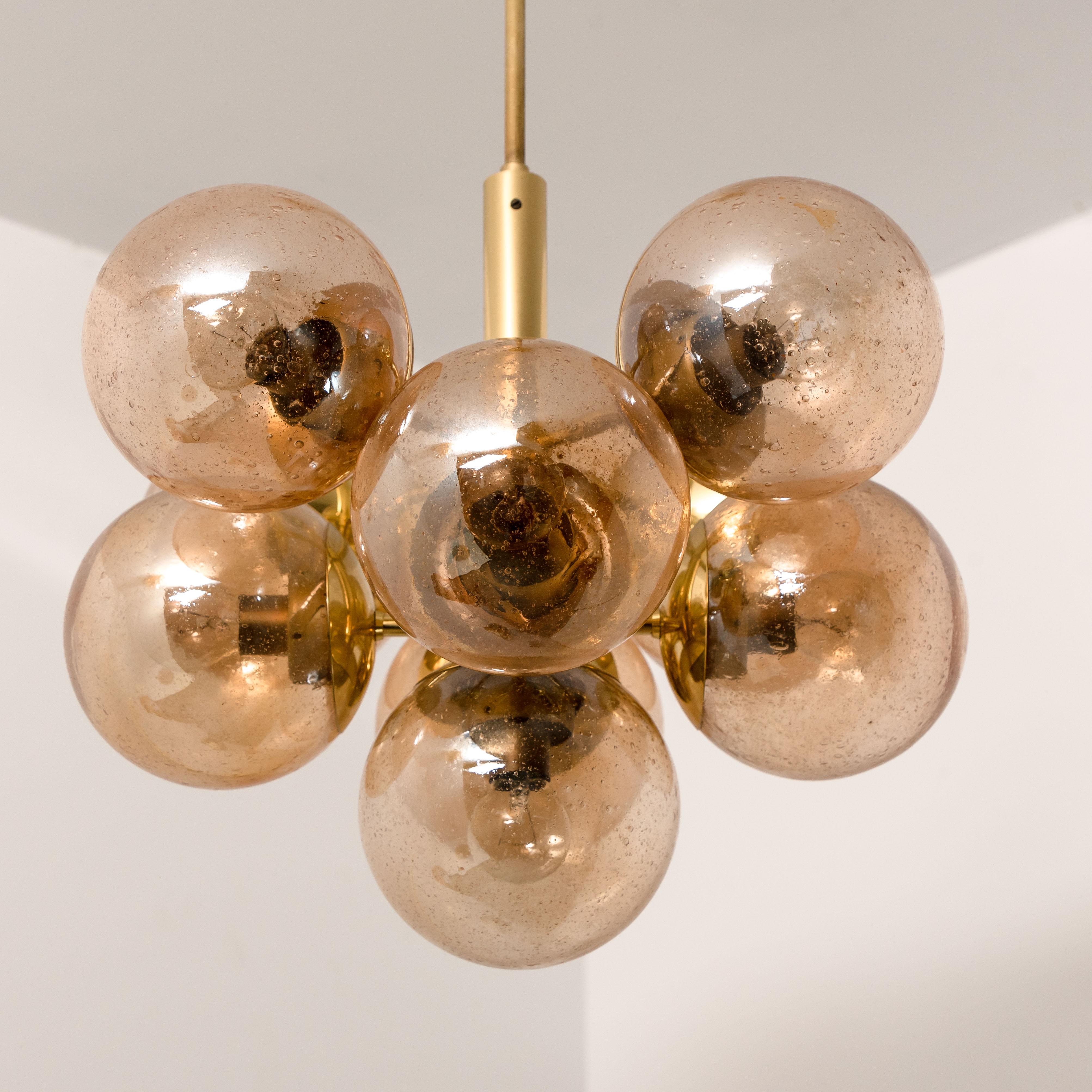 Gorgeous Kaiser chandelier with a molecular structure, much more dense visually than comparable Sputnik form chandeliers. A Brass central body is surround by 8 closely attached hand blown globes with smoked glass. Illuminates beautifully.

Height