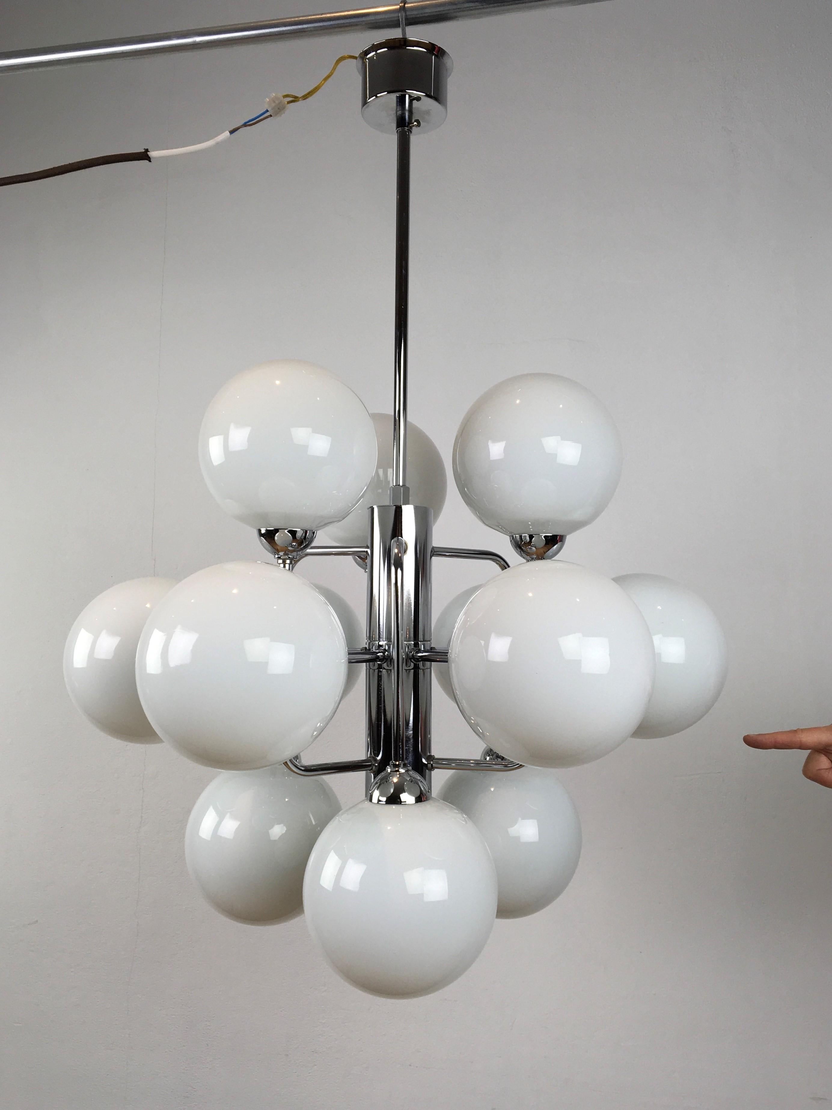 Modern chandelier of chrome with opaline glass globes - Molecular chandelier.
The chrome of this ceiling light is still in beautiful shiny condition. 
It has a kind of cubic chromed frame with 12 handblown opaline glass globes.
This European light
