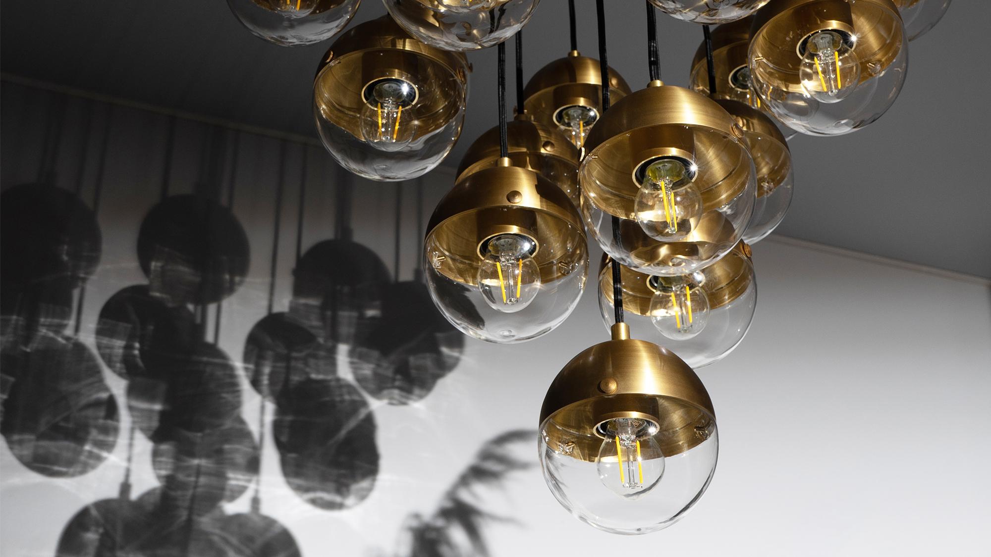 This hovering assemblage of radiating elements glimmers with vital energy. Inspired by elemental shapes, nineteen half globes emit an atmospheric light, anchored to a circular brass plate.

Available in our three signature finishes: Lacquered