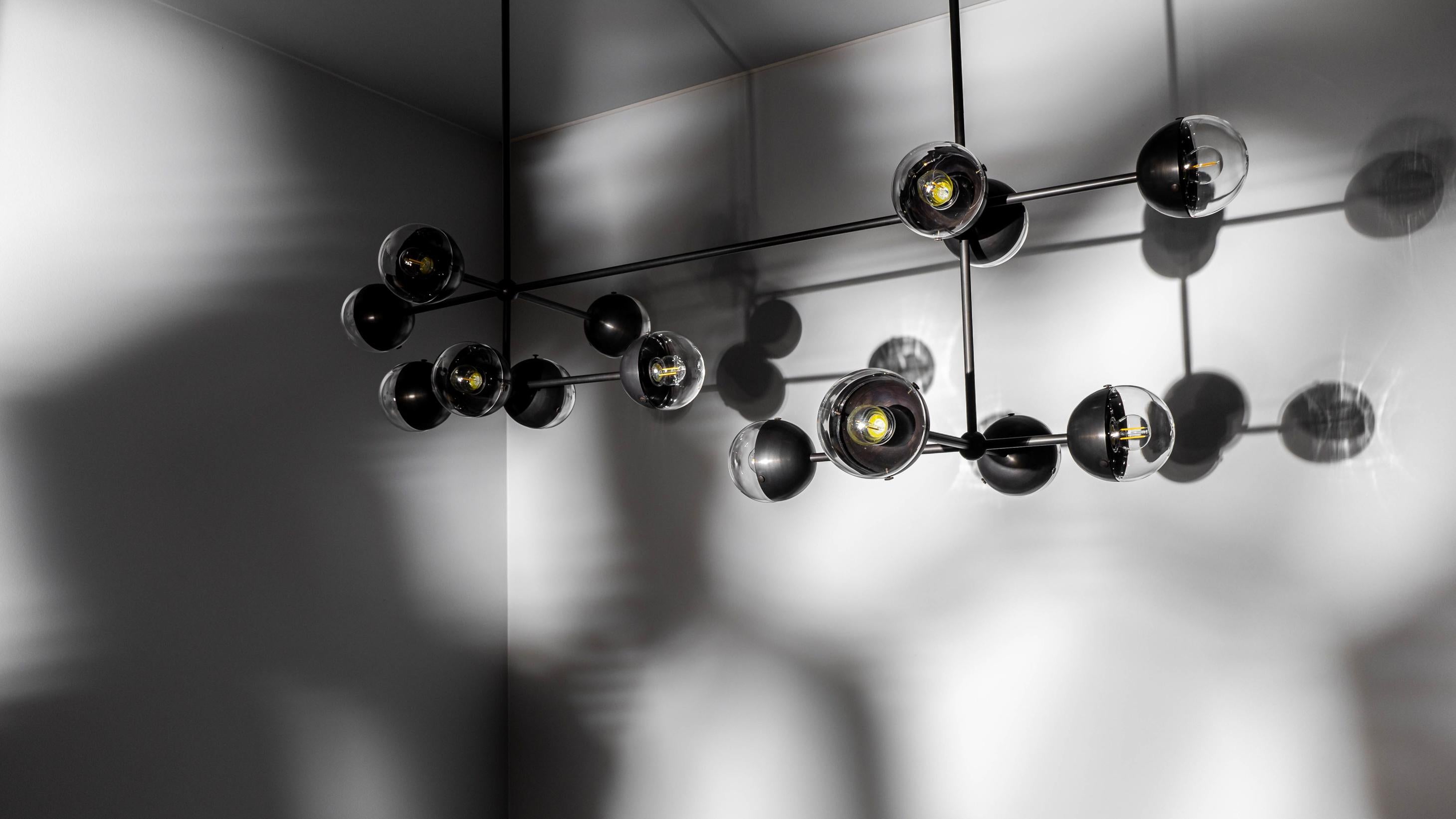 A fashionable line of enclosed bulbs expands into a playful configuration of elemental proportions. This chandelier of electric light represents the unseen forces shaping our material world.

Available in our three signature finishes: Lacquered